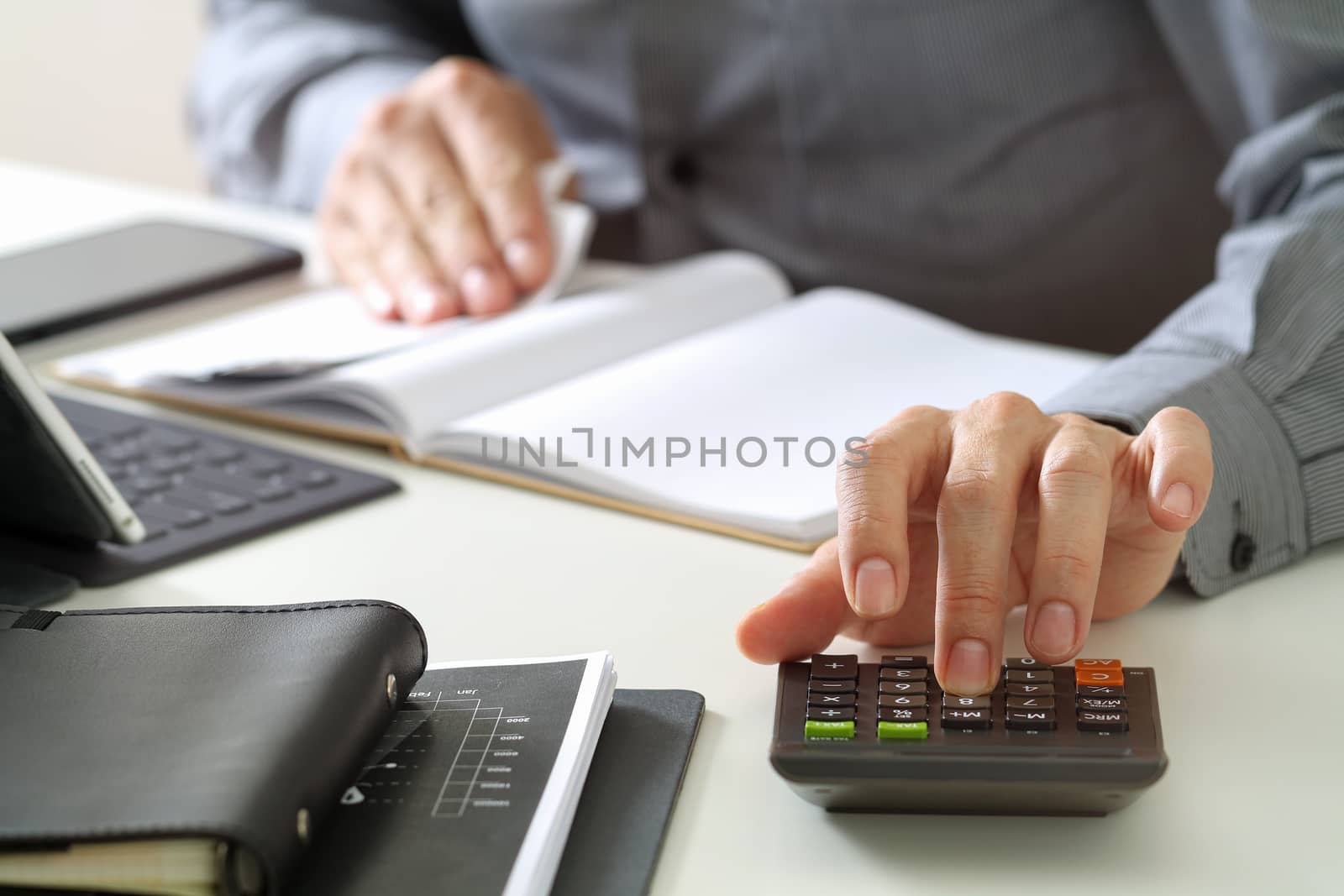 businessman hand working with finances about cost and calculator by everythingpossible