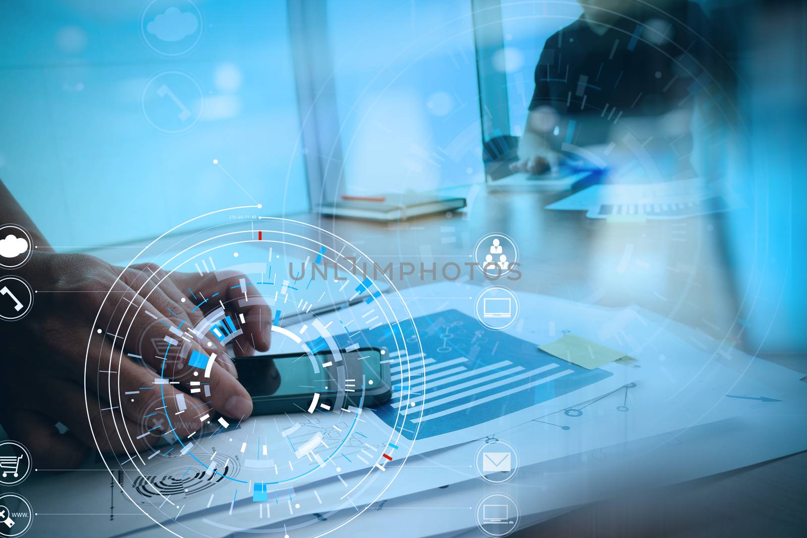 Hands of businessman using mobile phone in modern office with laptop and digital tablet computer with VR icon diagram