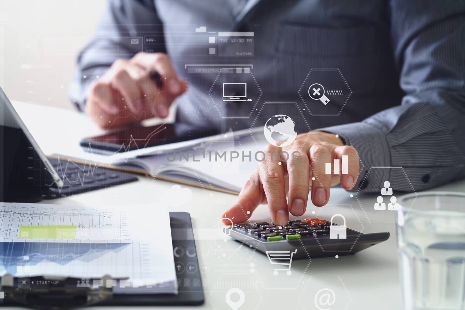 businessman hand working with finances about cost and calculator and latop with mobile phone on withe desk in modern office with VR icon diagram