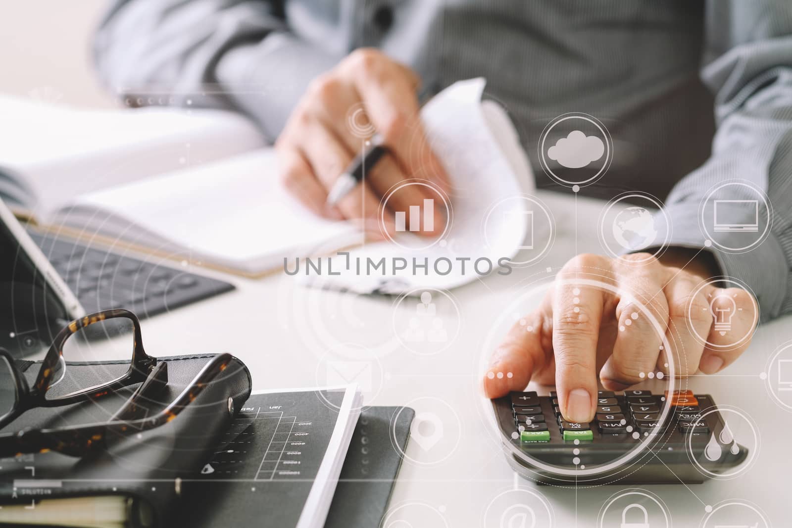 businessman hand working with finances about cost and calculator and latop with mobile phone on withe desk in modern office with VR icon diagram