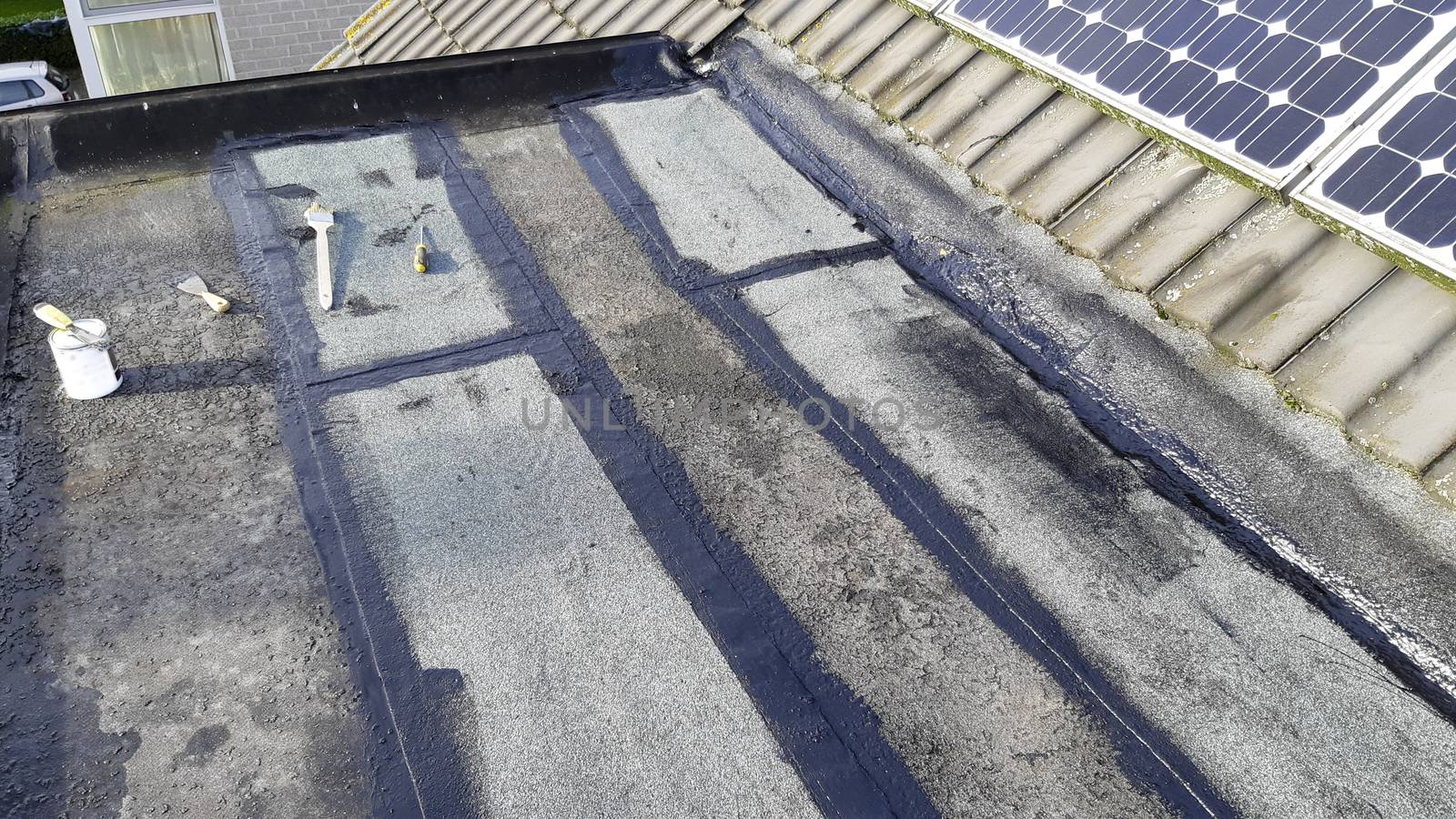 Tar foil roof repair: new patches installed to prevent further leaking from the roof. Emergency repair.
