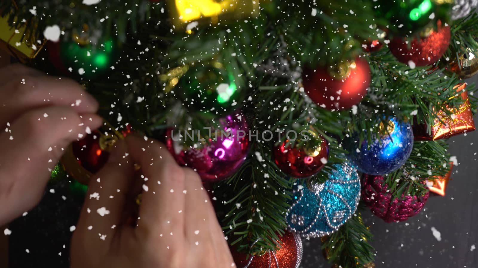 Greeting Season concept.hand setting of ornaments on a Christmas tree with decorative light