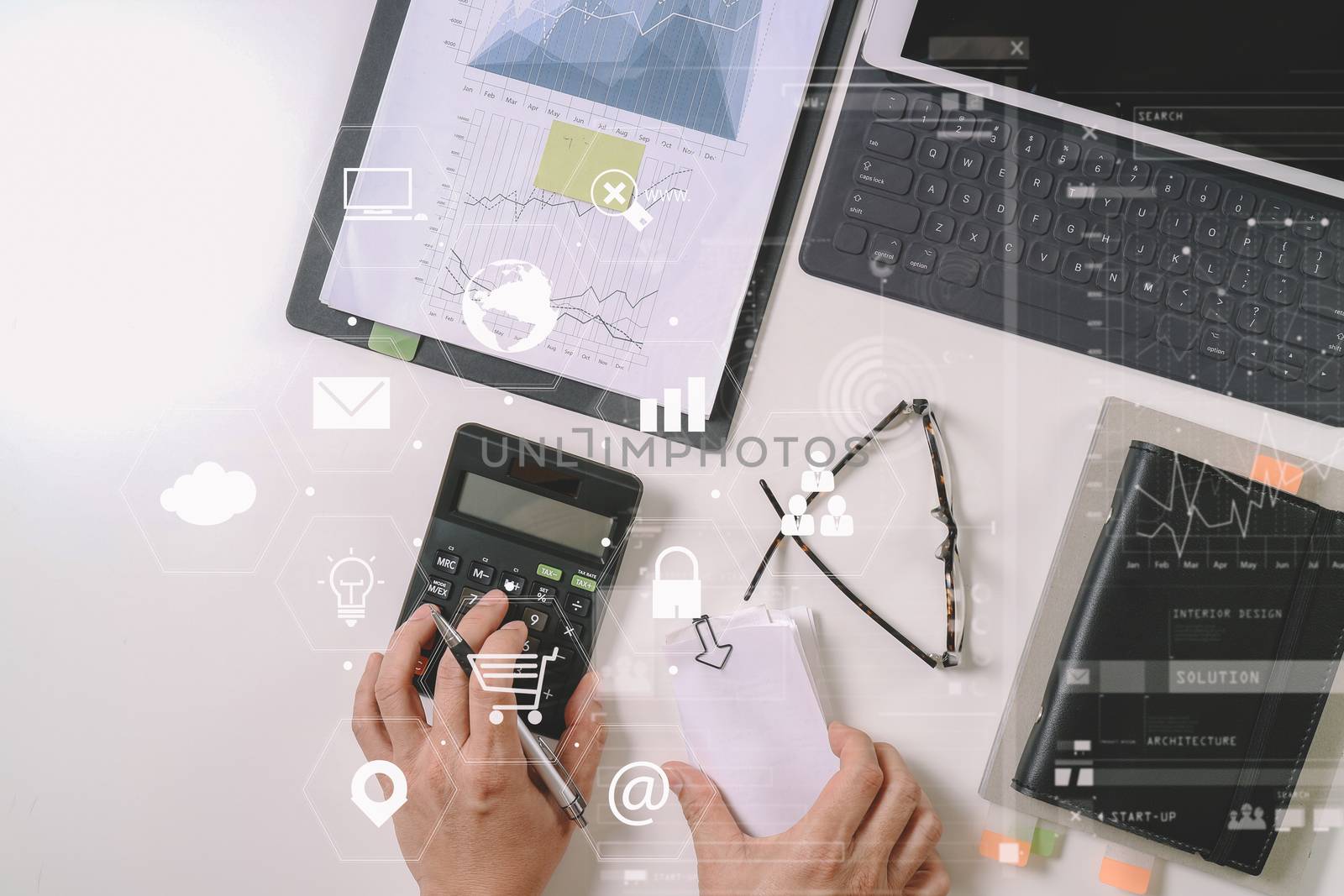 top view of businessman hand working with finances about cost and calculator and latop with mobile phone on withe desk in modern office with VR icon diagram