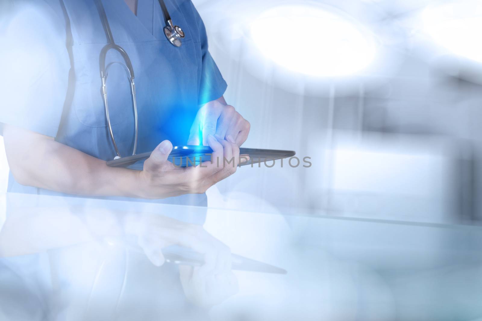 Doctor working with tablet computer on blue background  by everythingpossible