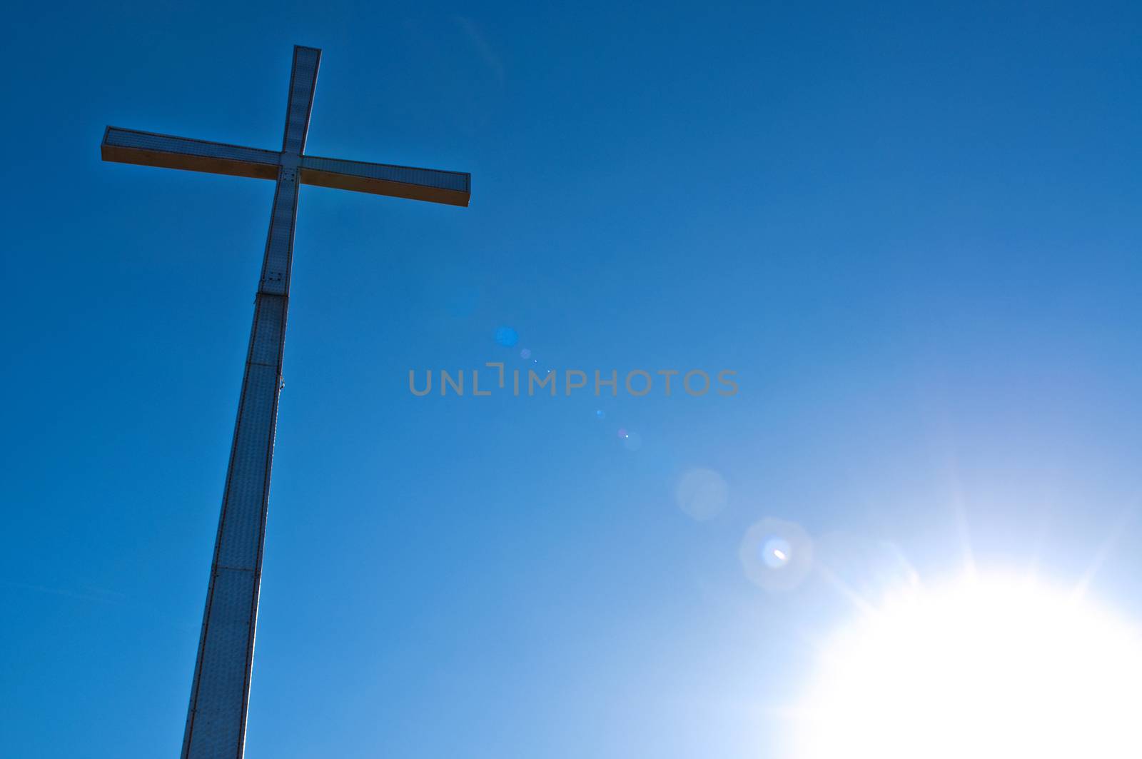 cross with sky and sun in the background