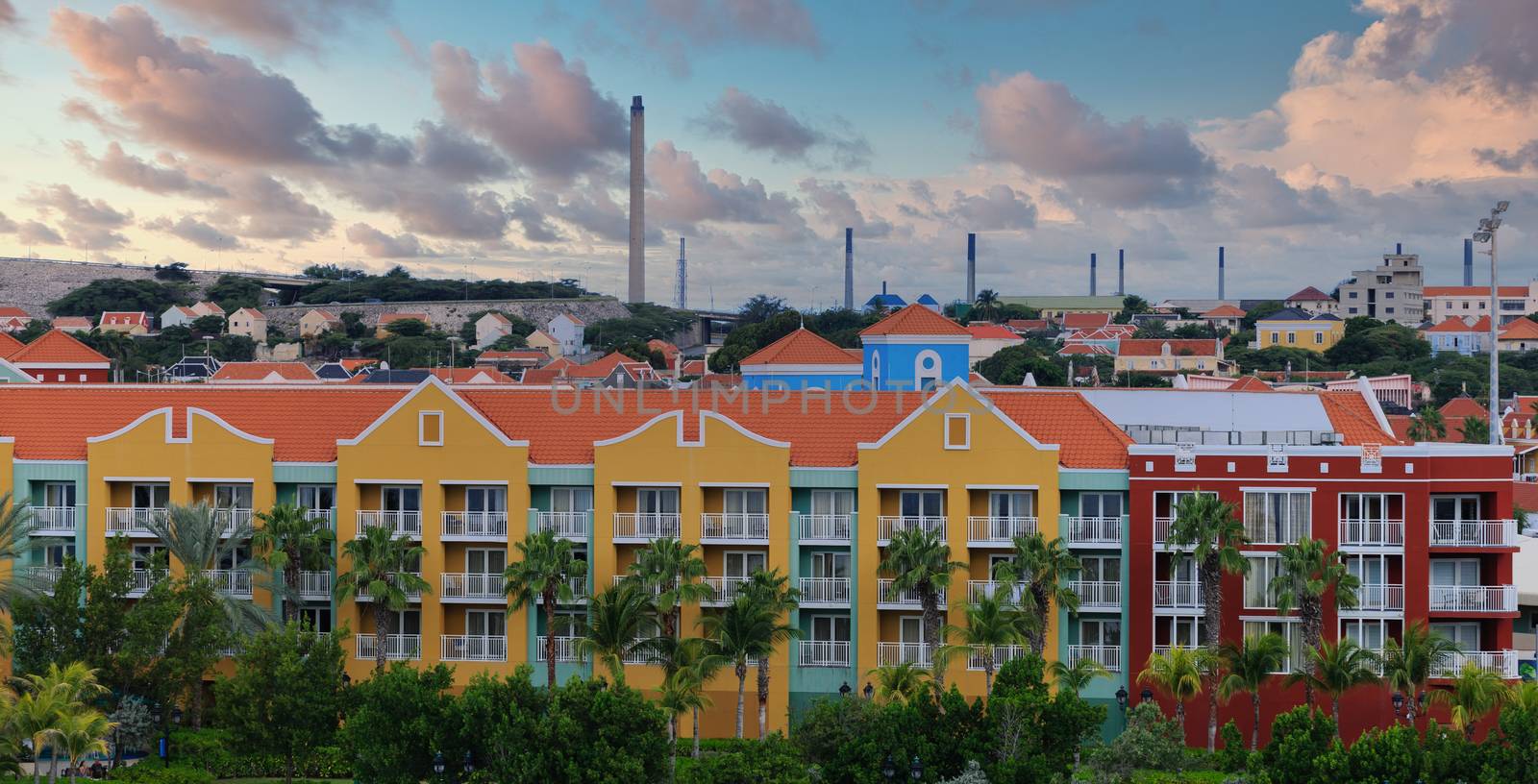 Colorful Resort with Oil Refinery Smokestacks in Background by dbvirago