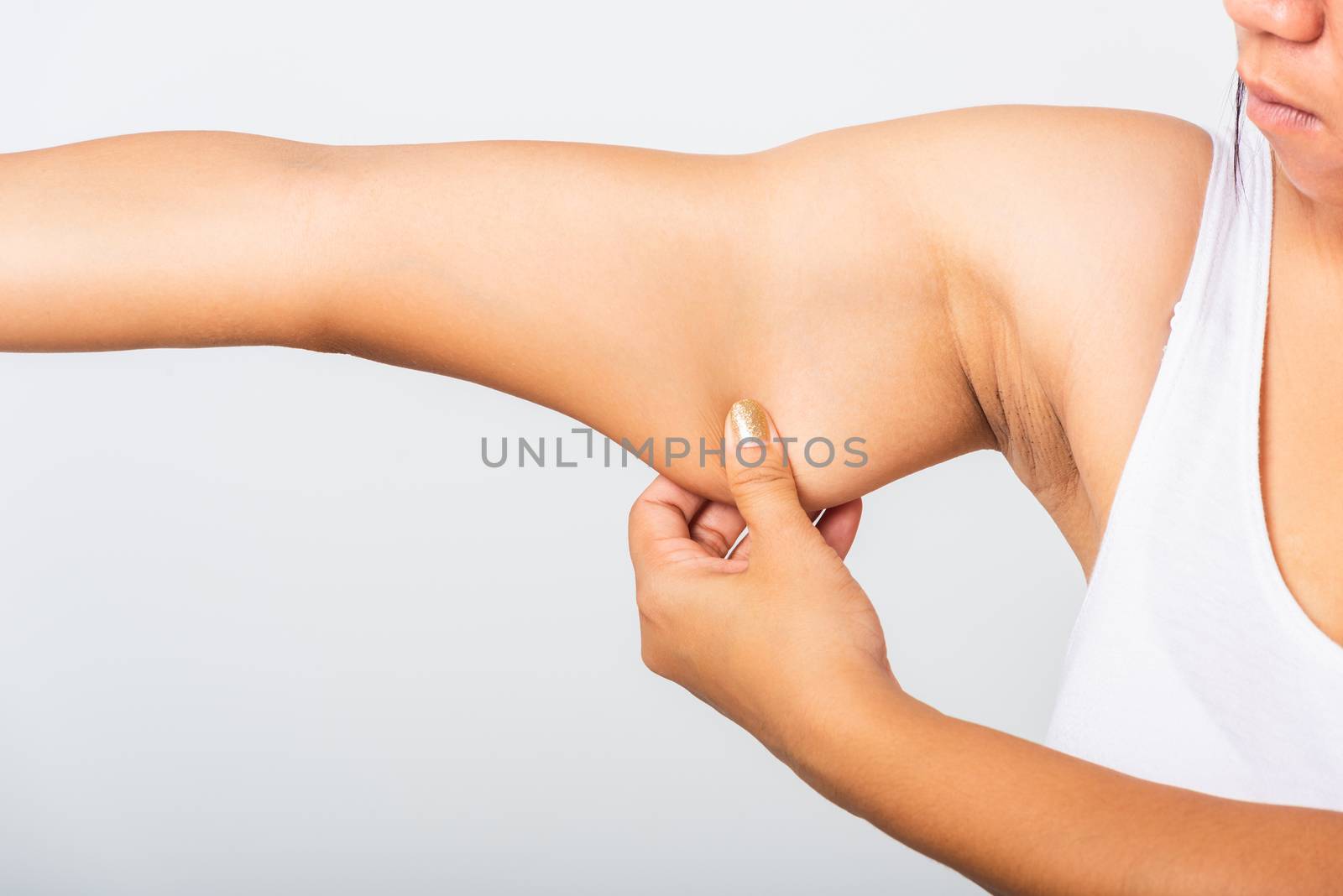 Close up of Asian woman pulling excess fat on her under arm, problem armpit skin, studio isolated on white background, Healthy overweight excess body concept