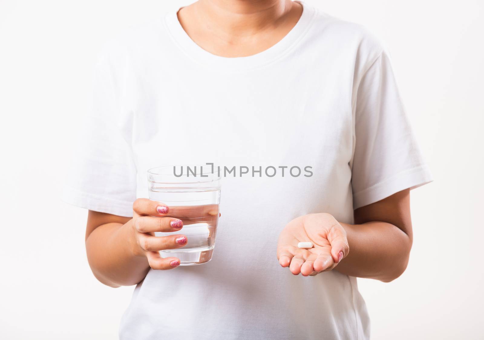 Closeup young Asian woman hold pill drugs in hand ready take medicines with a glass of water, studio shot isolated on white background, Healthcare and medical pharmacy concept