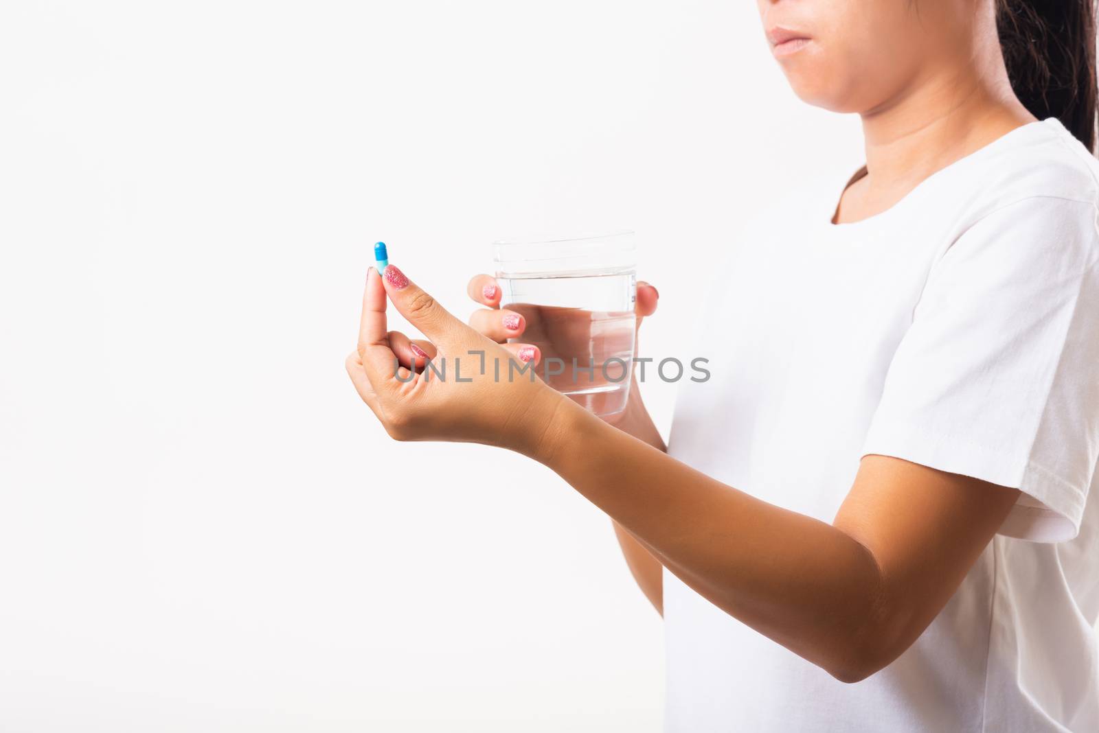 Woman hold pill drugs in hand ready take medicines with a glass  by Sorapop