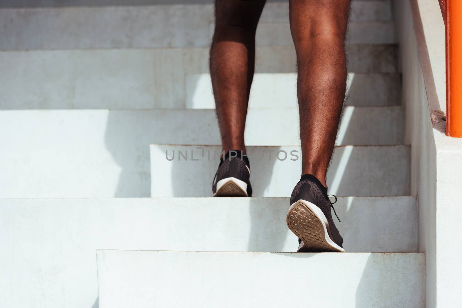 Close up athlete shoes of legs young sport runner black man step running up to climbing stairs doing training cardio sport workout at the outdoor street, healthy exercise before workout concept