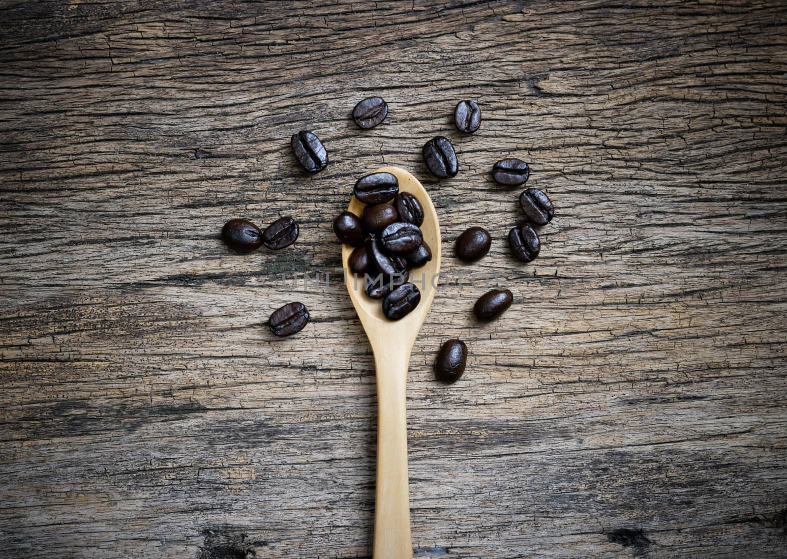 Coffee cup and coffee beans roasted in a sack on a wooden floor.