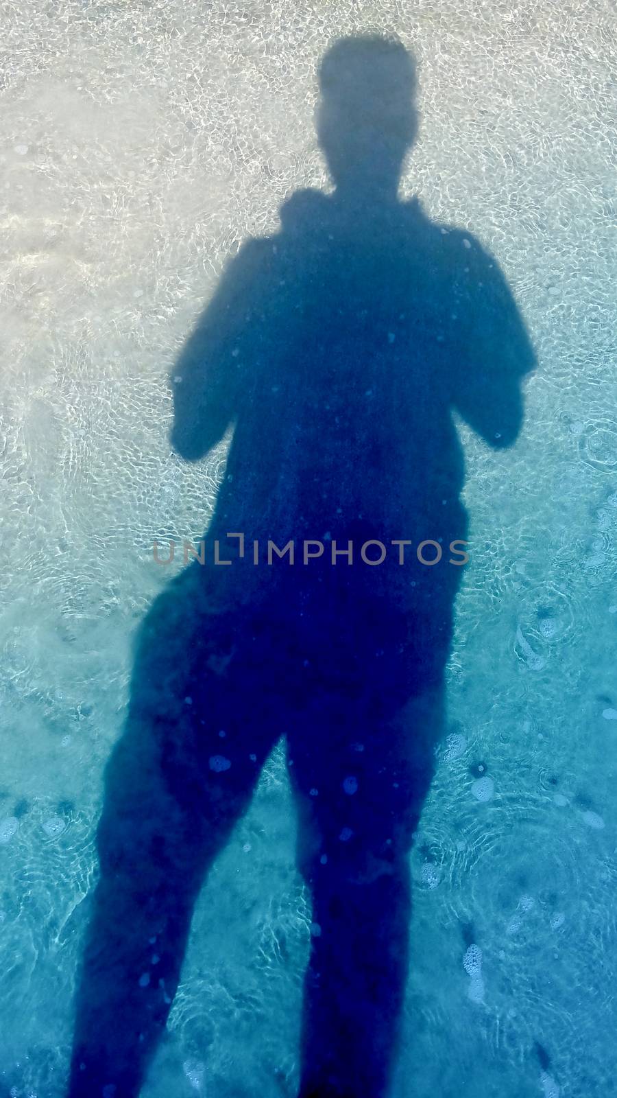 man and shadow stand on sea water surface