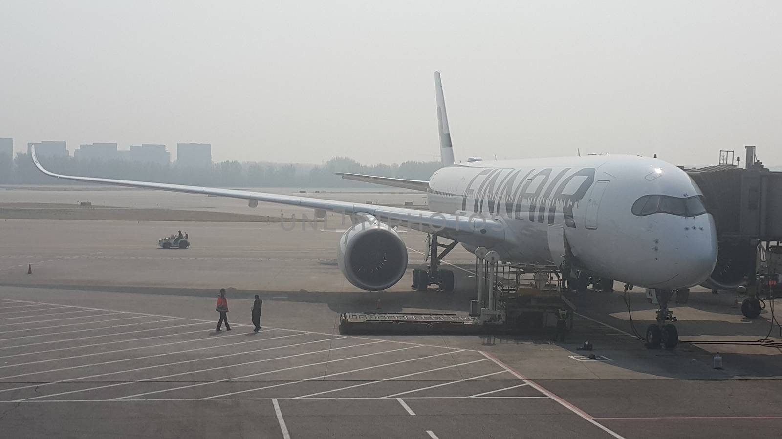 Passenger plane standing in airport on the concrete paved runway terminal by Photochowk