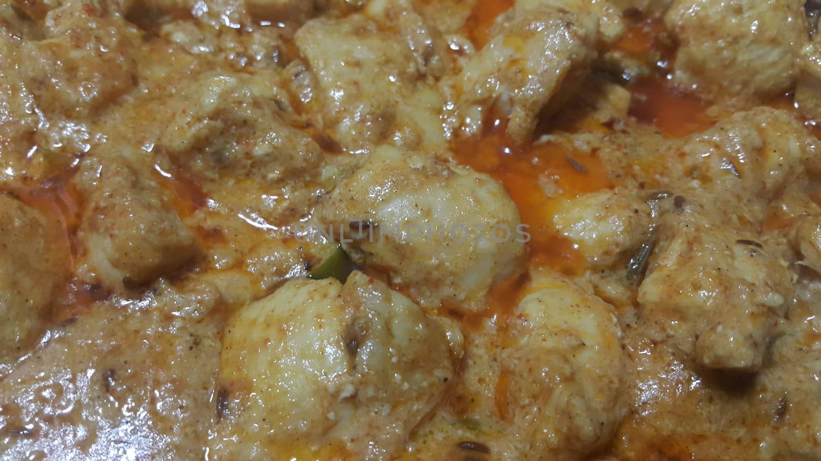 A close up view of stewed chicken meat cubes with spices on it by Photochowk