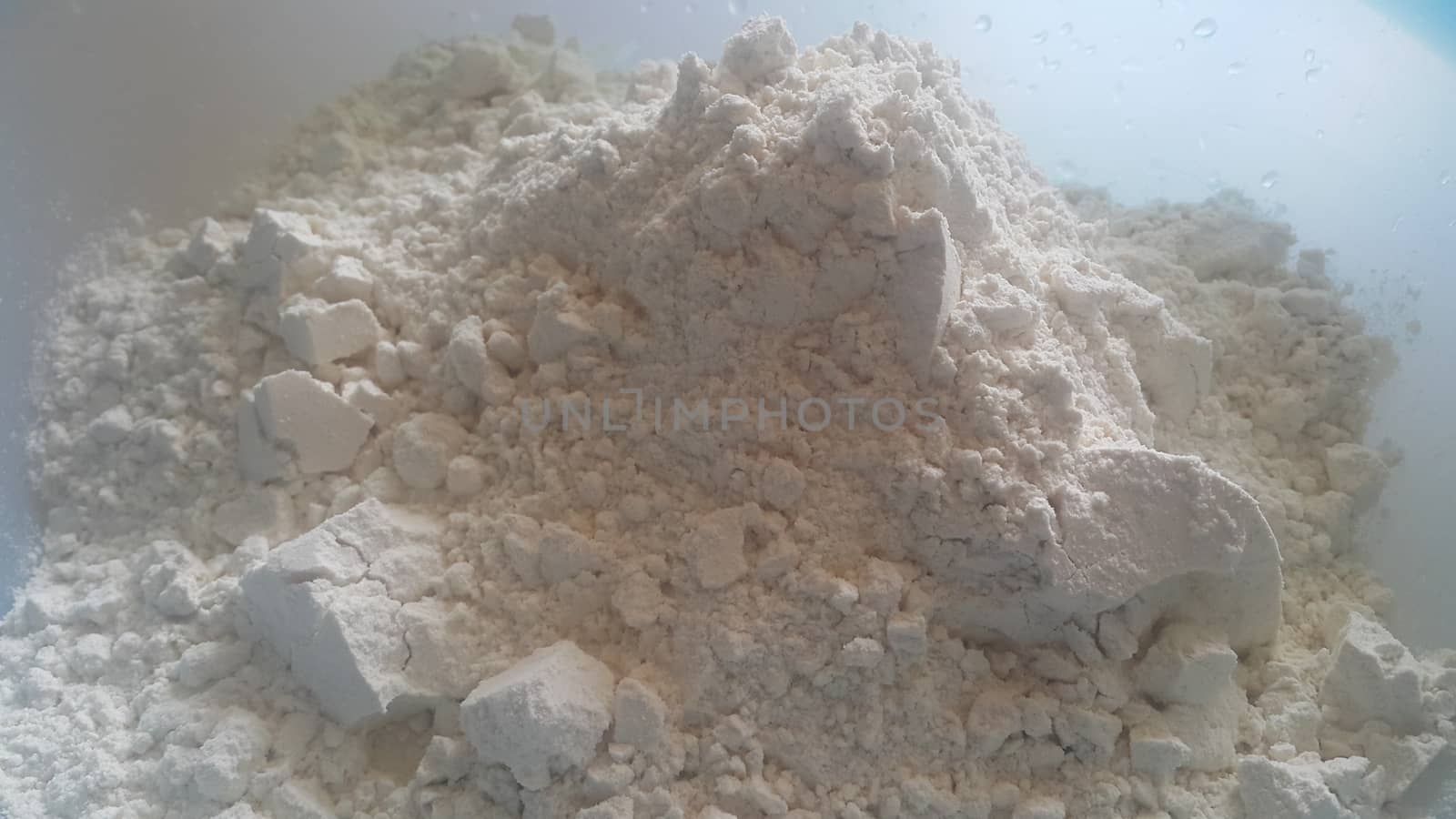 Closeup view of wheat flour heap placed in market for sale. White flour background