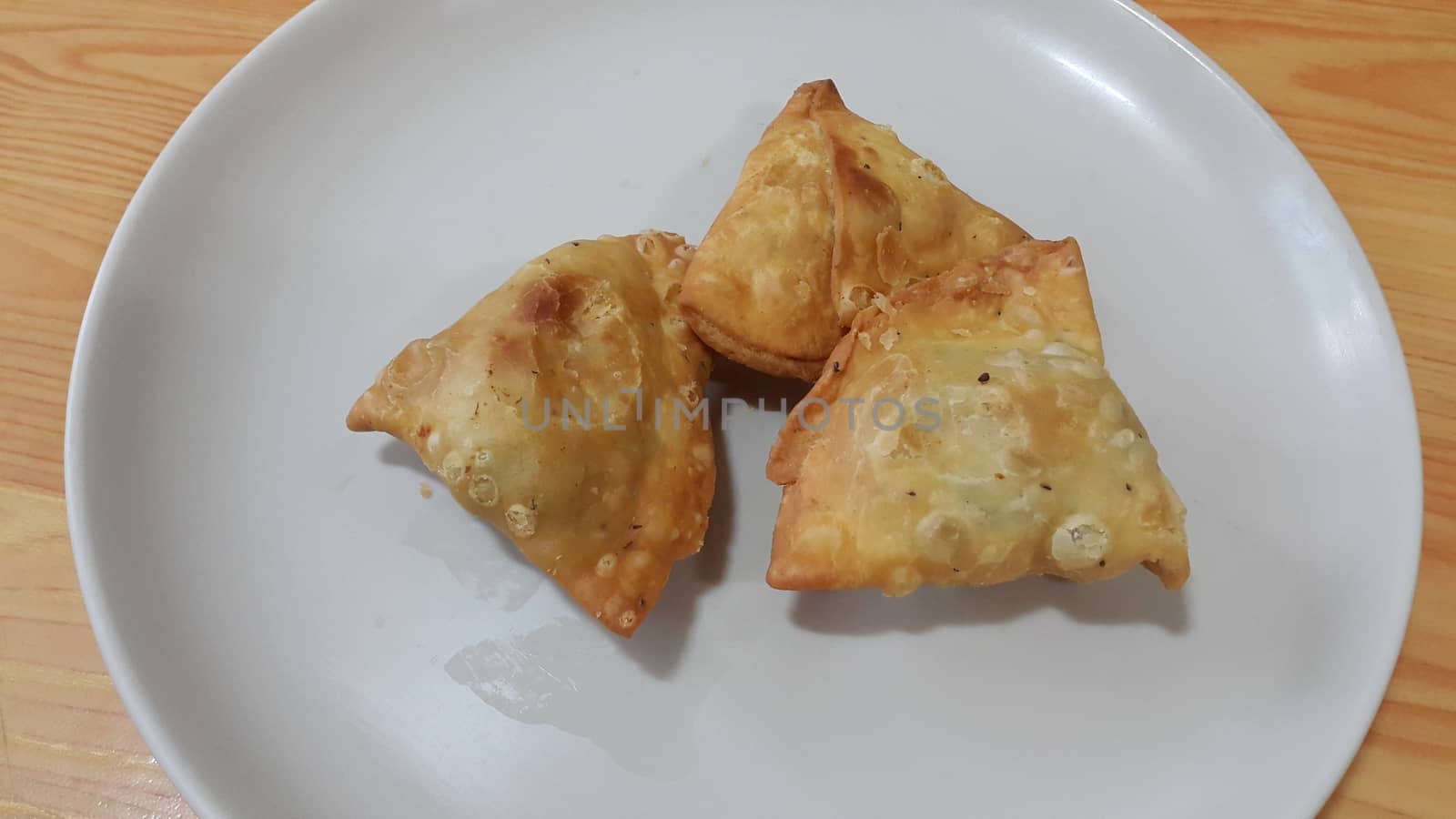 Closeup of delicious home made samosa or pastries food on white background by Photochowk