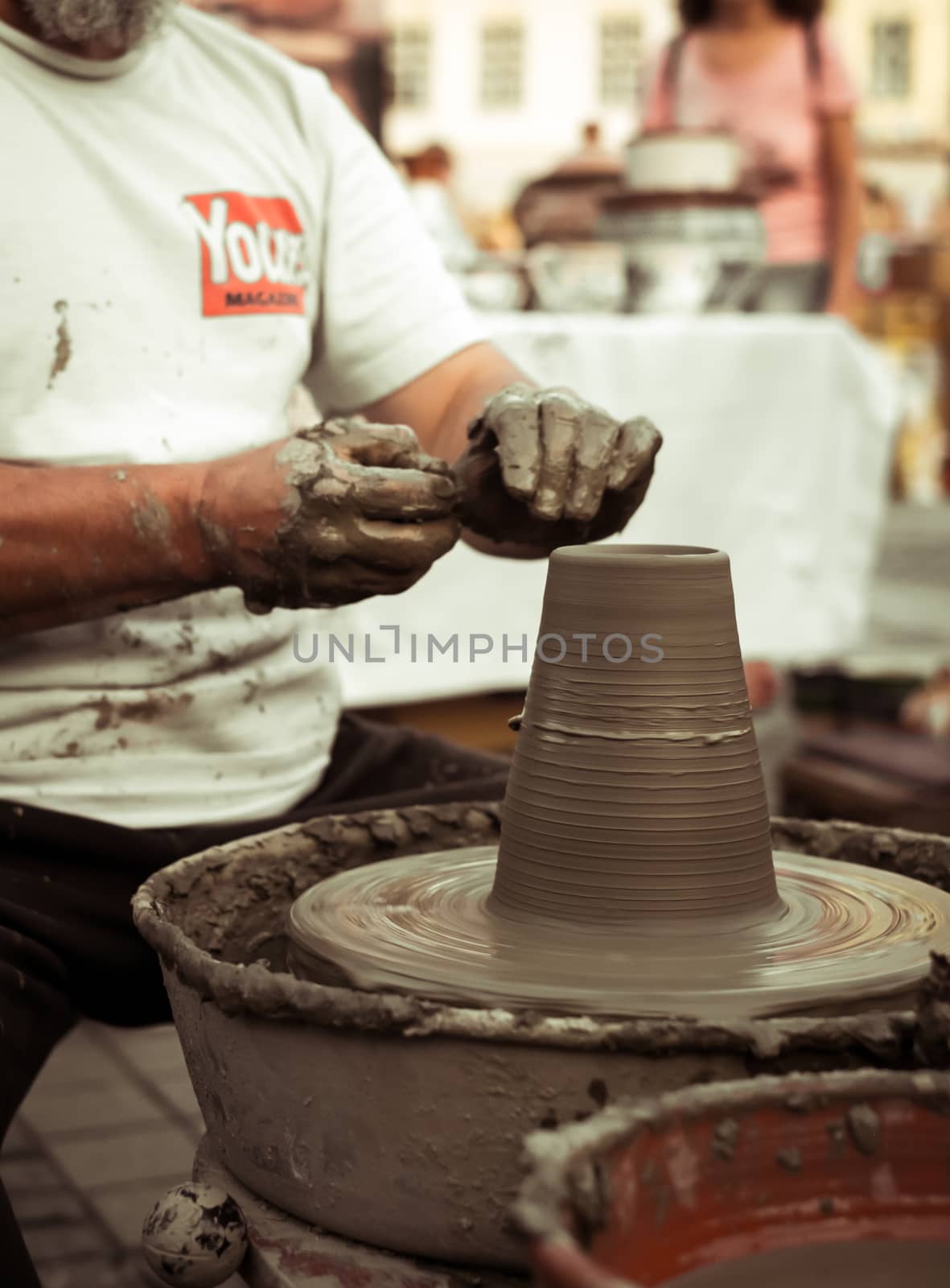 Sibiu City, Romania - 31 August 2019. Hands of a potter shaping a clay pot on a potter's wheel at the potters fair from Sibiu, Romania