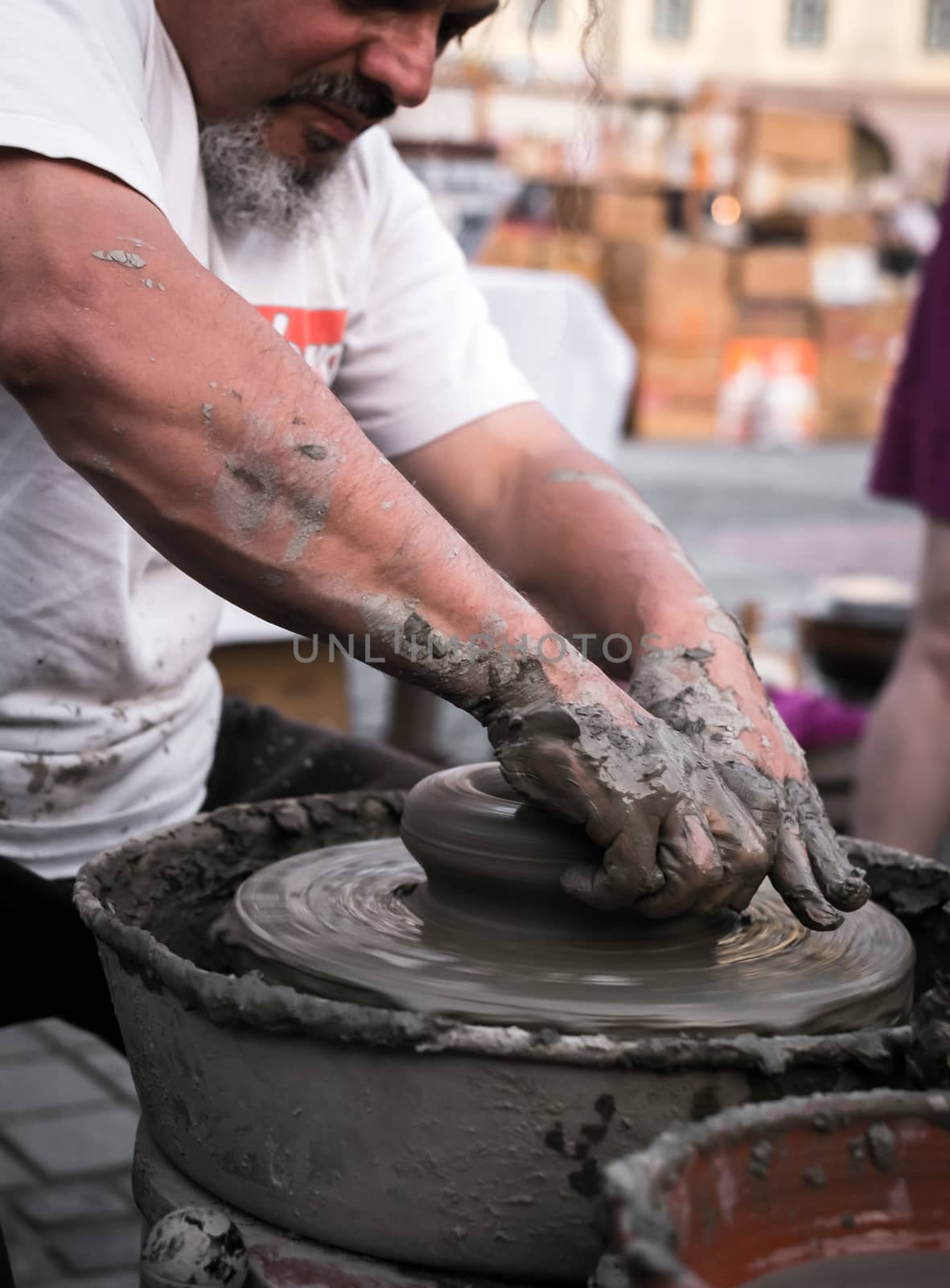 Sibiu City, Romania - 31 August 2019. Hands of a potter shaping a clay pot on a potter's wheel at the potters fair from Sibiu, Romania