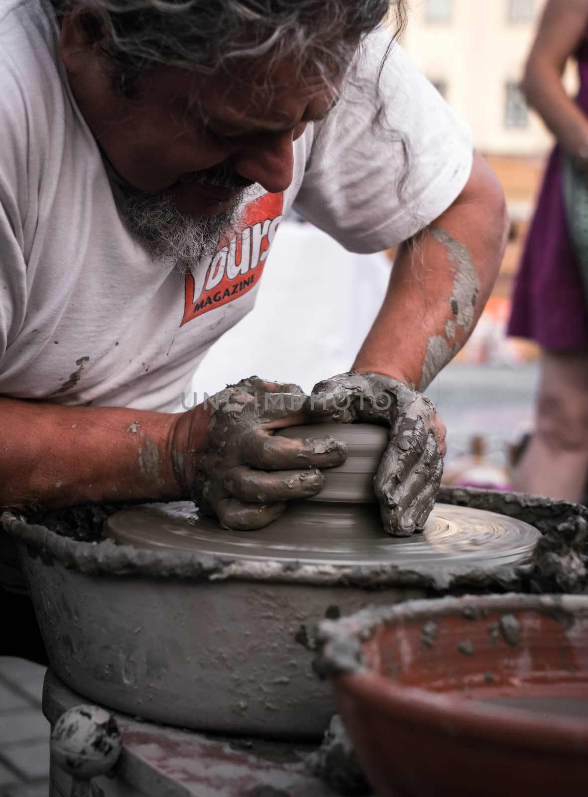 Sibiu City, Romania - 31 August 2019. Hands of a potter shaping a clay pot on a potter's wheel at the potters fair from Sibiu, Romania