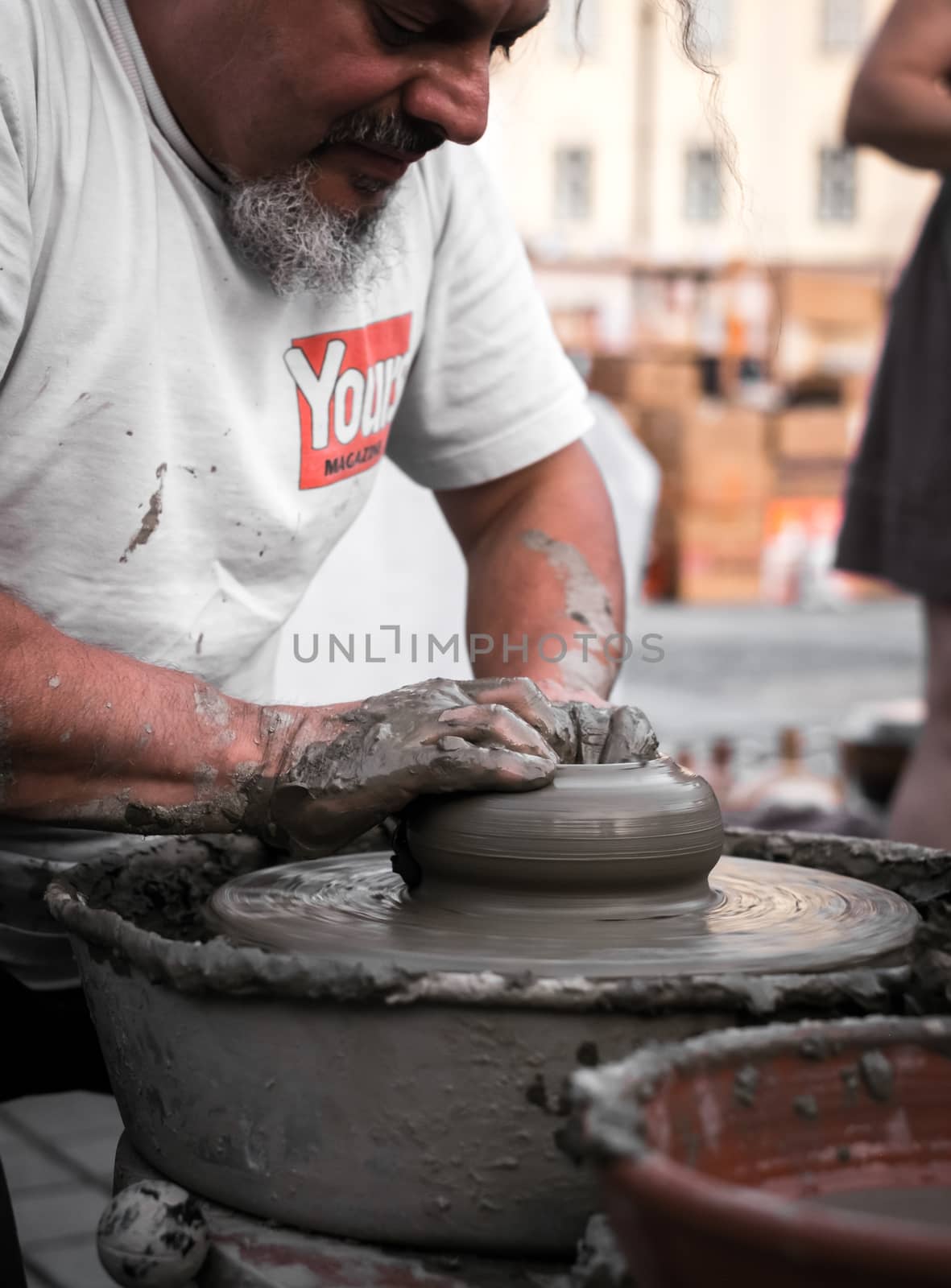 Sibiu City, Romania - 31 August 2019. Hands of a potter shaping a clay pot on a potter's wheel at the potters fair from Sibiu, Romania