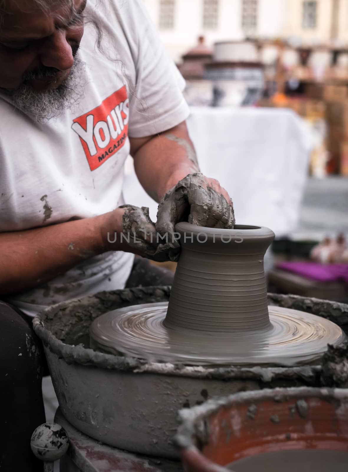 Sibiu City, Romania - 31 August 2019. Hands of a potter shaping a clay pot on a potter's wheel at the potters fair from Sibiu, Romania