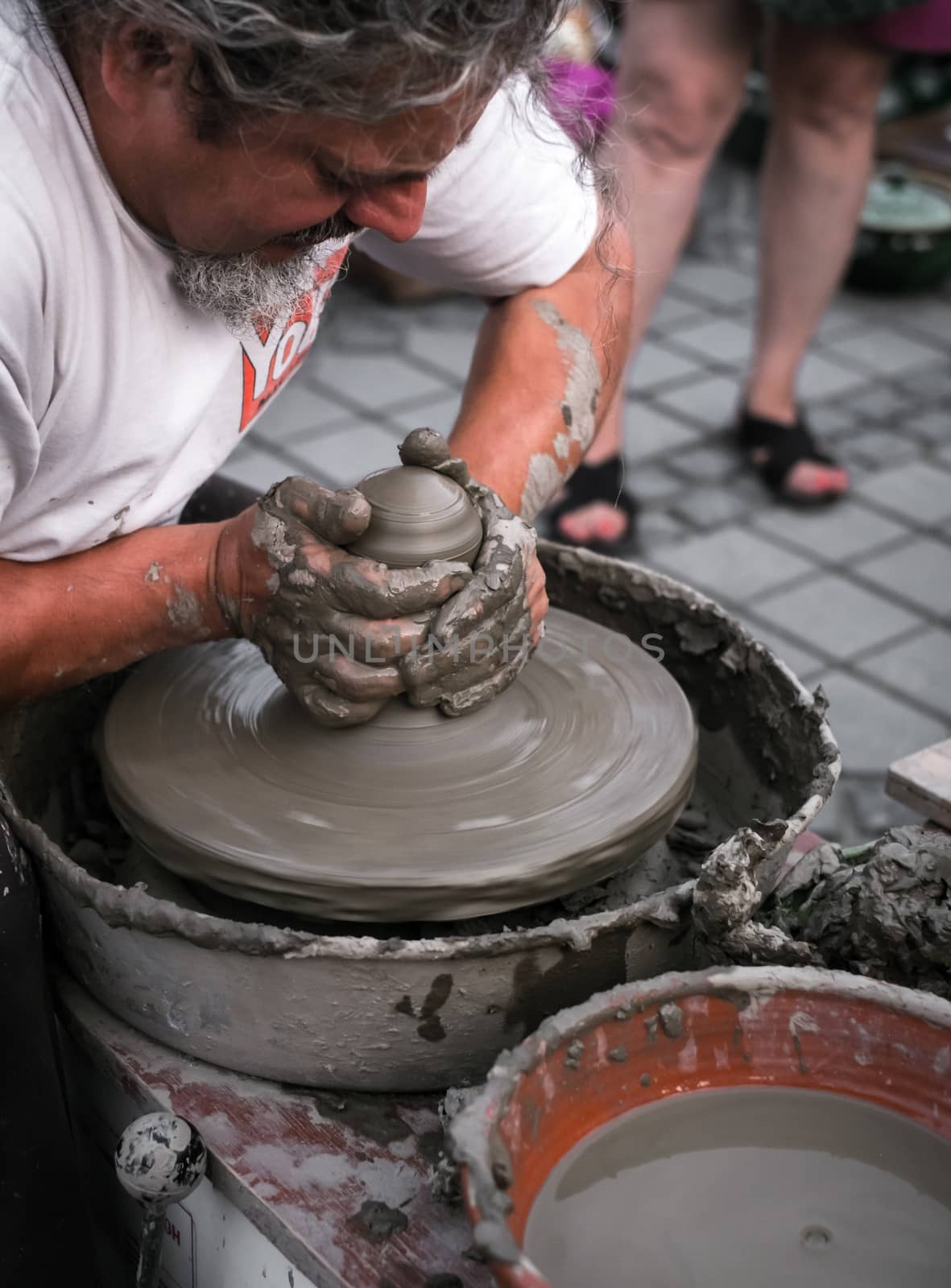 Sibiu City, Romania - 31 August 2019. Hands of a potter shaping a clay pot on a potter's wheel at the potters fair from Sibiu, Romania