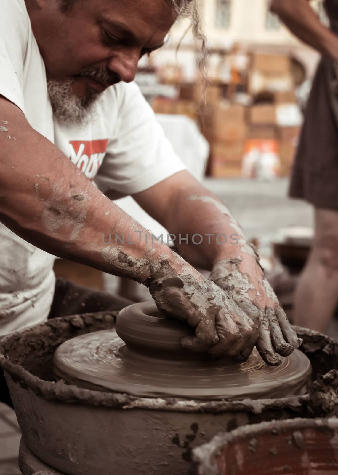 Sibiu City, Romania - 31 August 2019. Hands of a potter shaping a clay pot on a potter's wheel at the potters fair from Sibiu, Romania