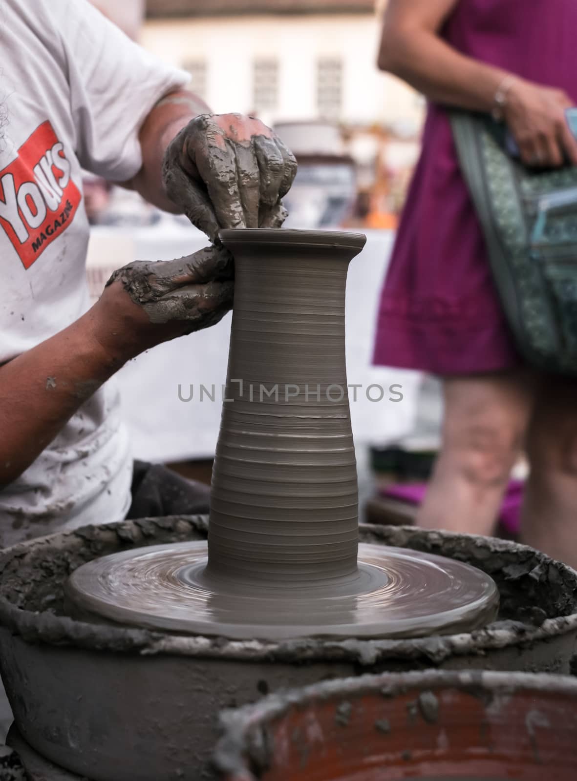 Sibiu City, Romania - 31 August 2019. Hands of a potter shaping a clay pot on a potter's wheel at the potters fair from Sibiu, Romania