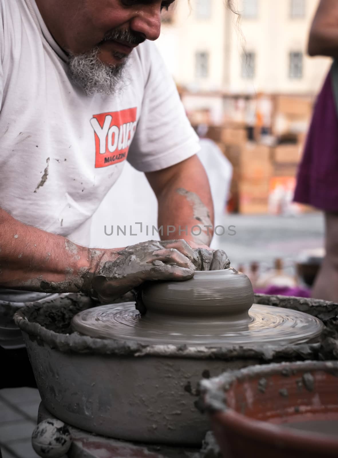 Sibiu City, Romania - 31 August 2019. Hands of a potter shaping a clay pot on a potter's wheel at the potters fair from Sibiu, Romania