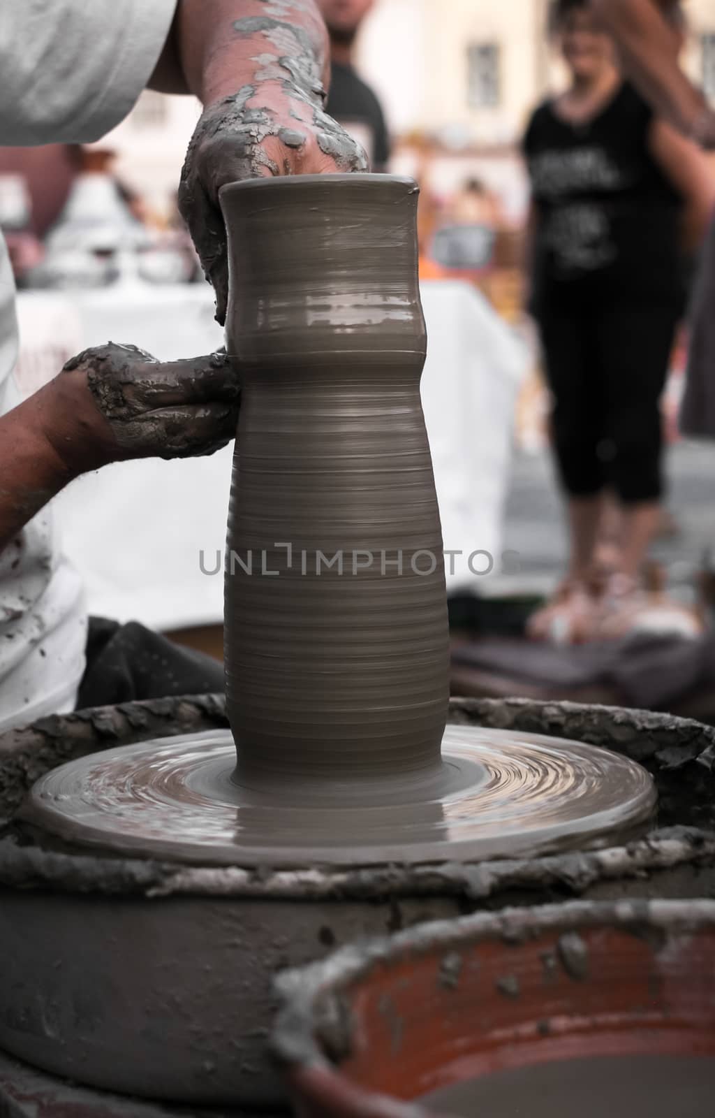 Sibiu City, Romania - 31 August 2019. Hands of a potter shaping a clay pot on a potter's wheel at the potters fair from Sibiu, Romania