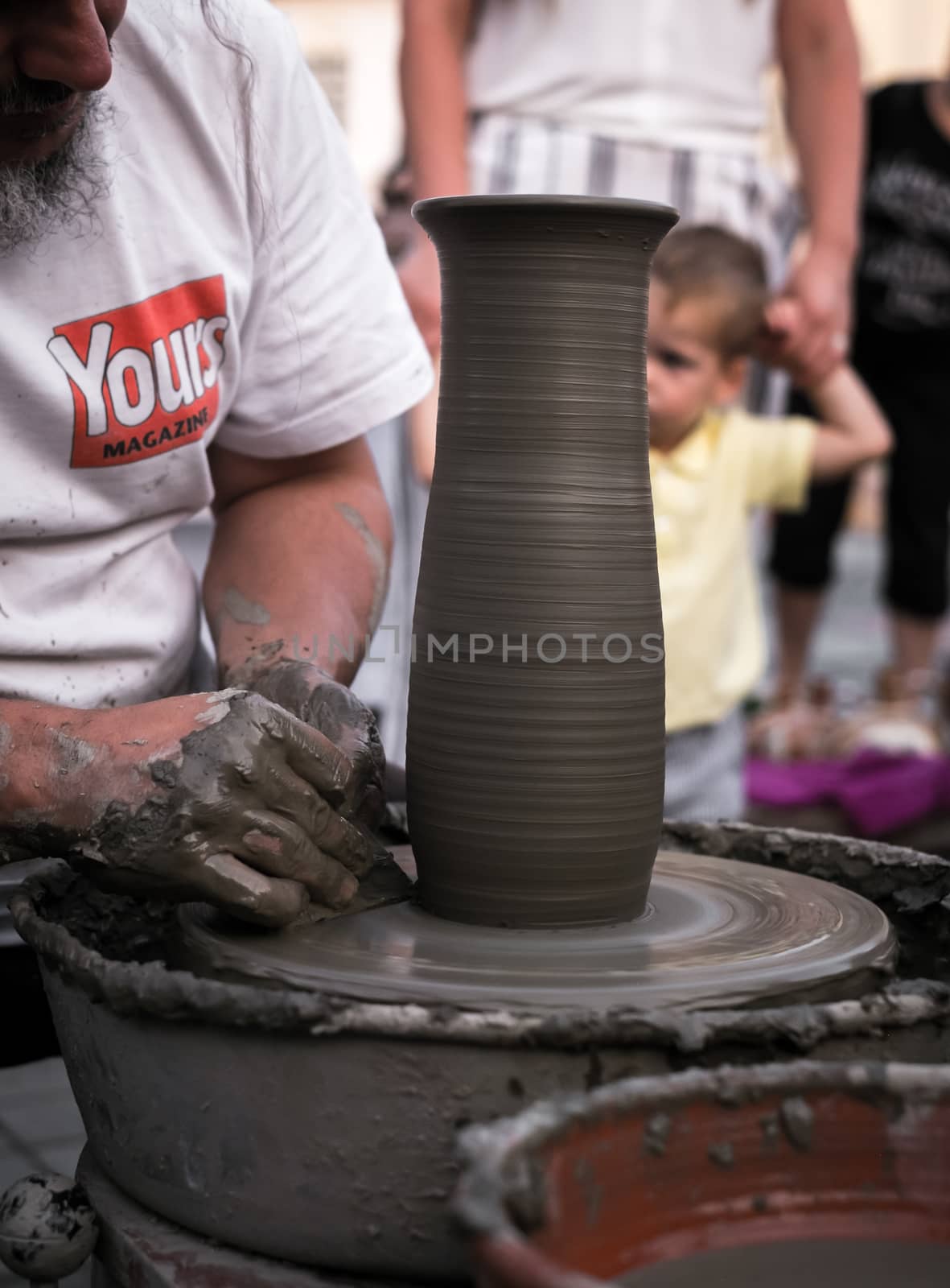 Sibiu City, Romania - 31 August 2019. Hands of a potter shaping a clay pot on a potter's wheel at the potters fair from Sibiu, Romania