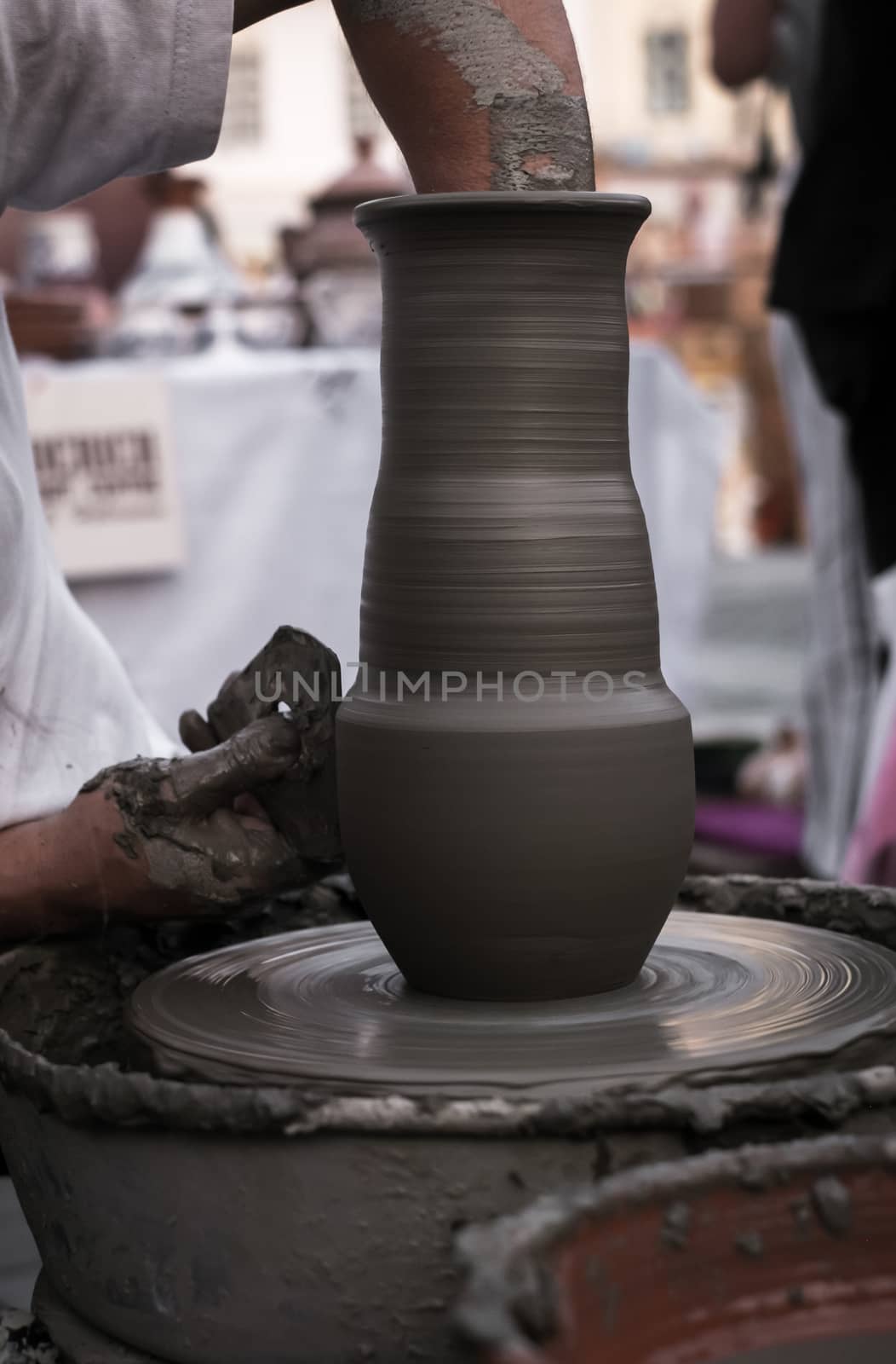 Sibiu City, Romania - 31 August 2019. Hands of a potter shaping a clay pot on a potter's wheel at the potters fair from Sibiu, Romania