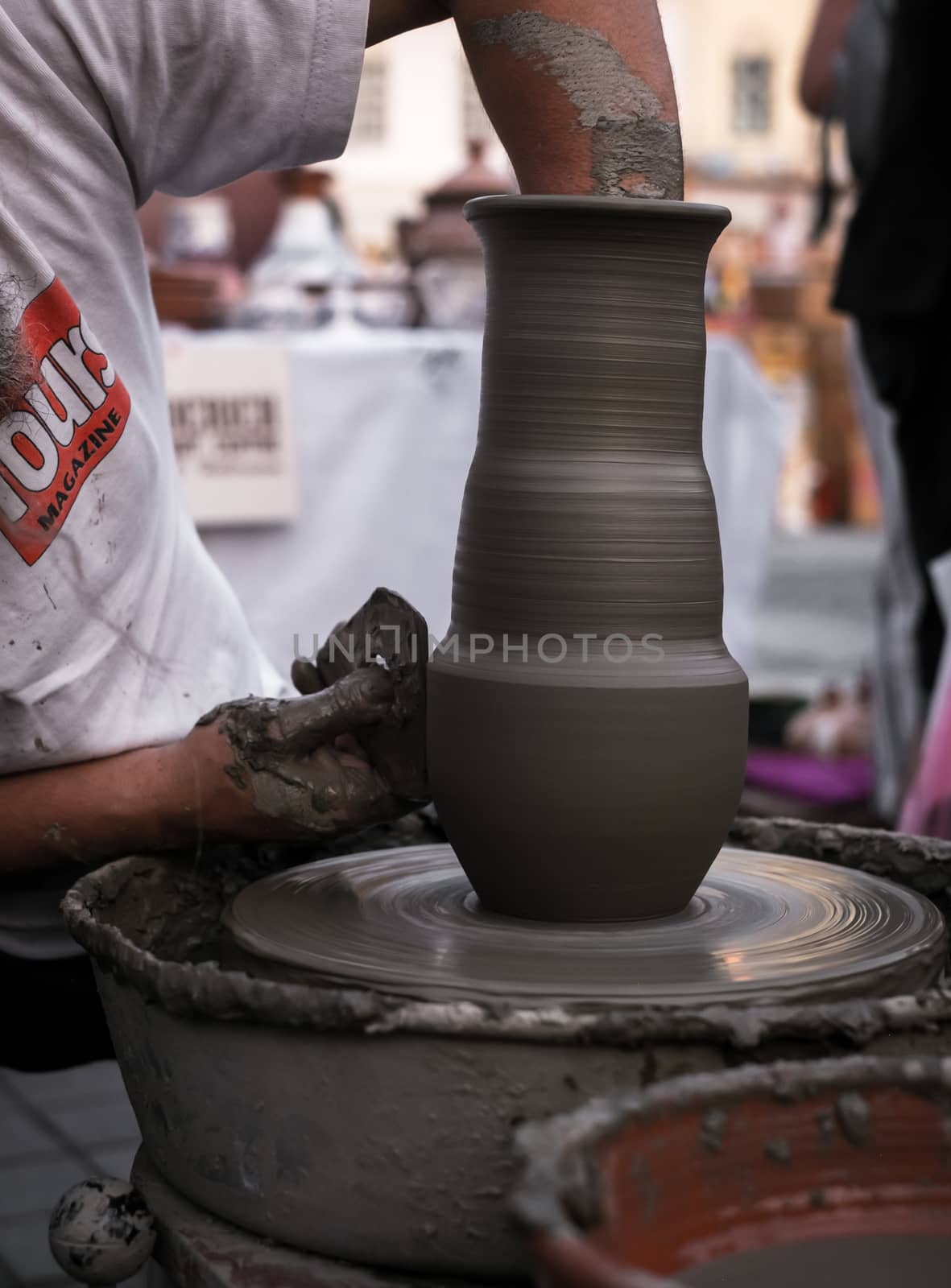 Sibiu City, Romania - 31 August 2019. Hands of a potter shaping a clay pot on a potter's wheel at the potters fair from Sibiu, Romania