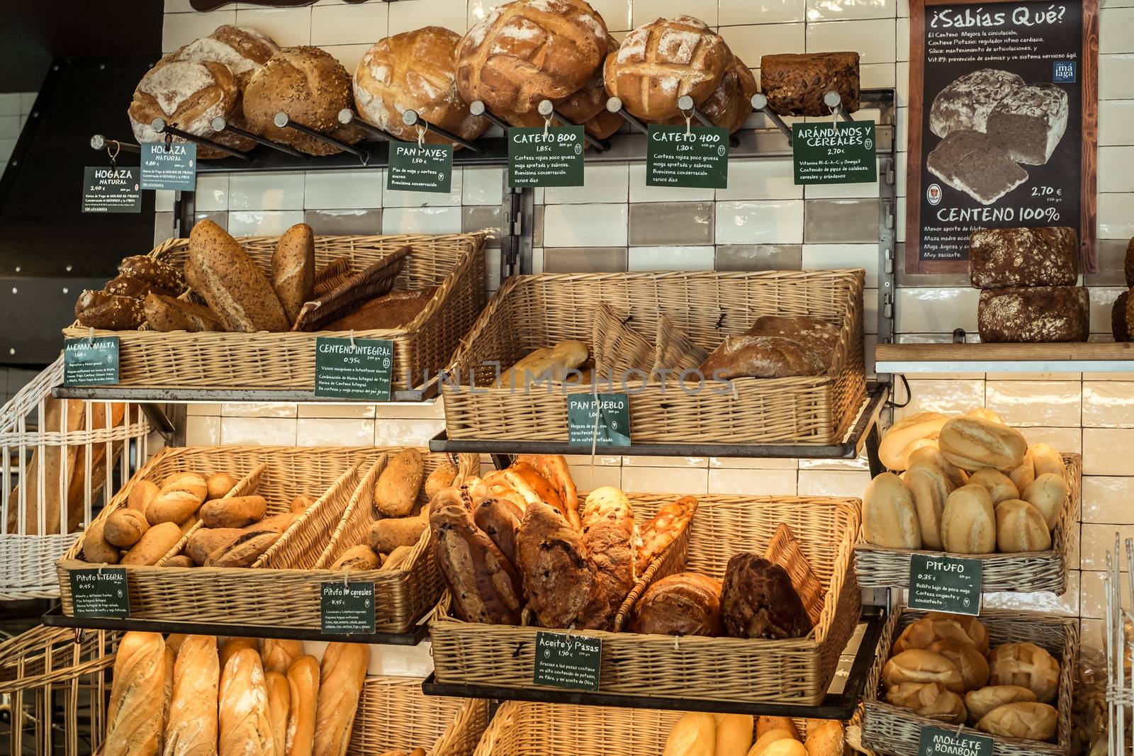 Malaga, Spain - August 04, 2018. Variety of fresh baked bread in bakery shop in Malaga city, Spain