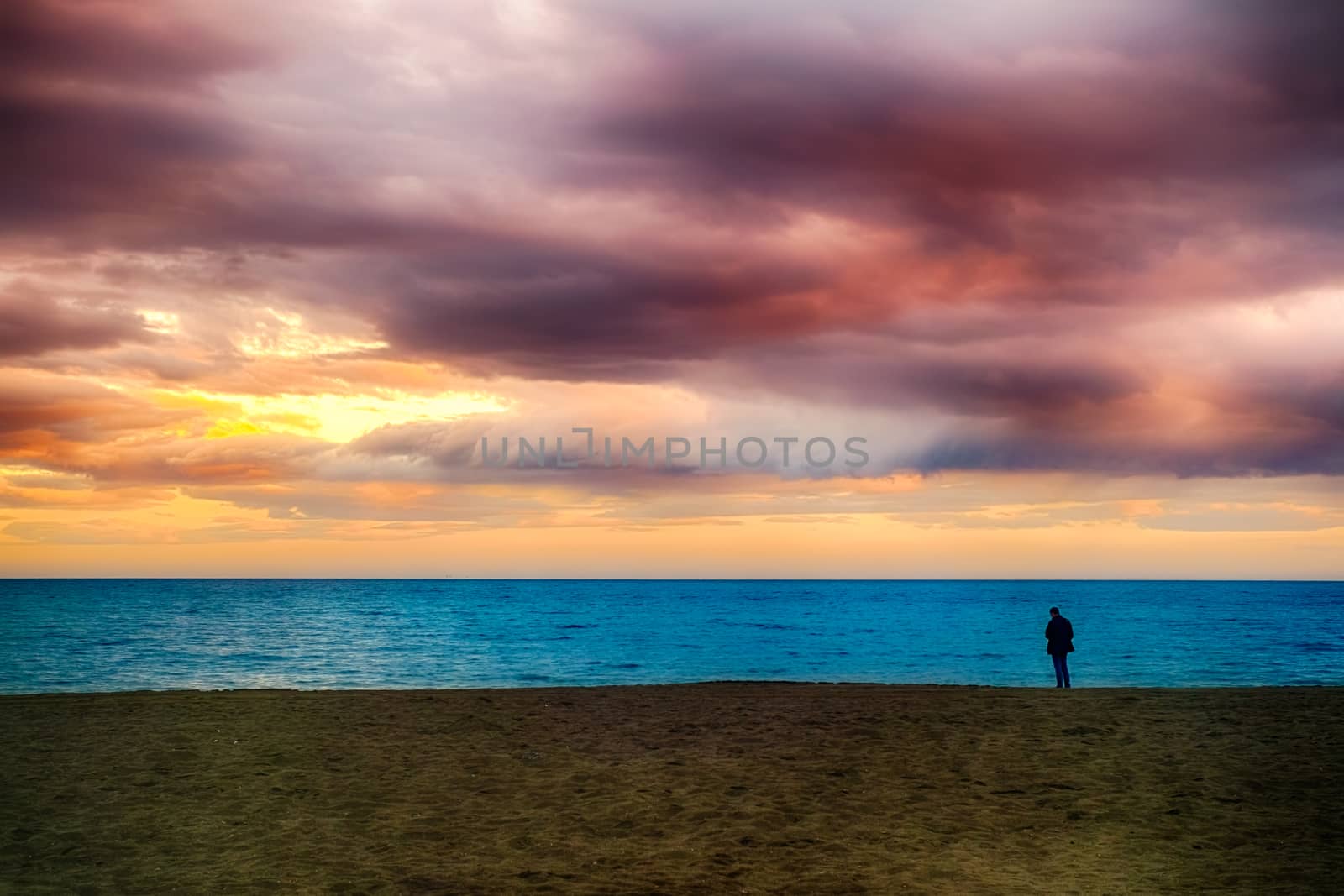 a man on the Mediterranean Sea beach at sunset