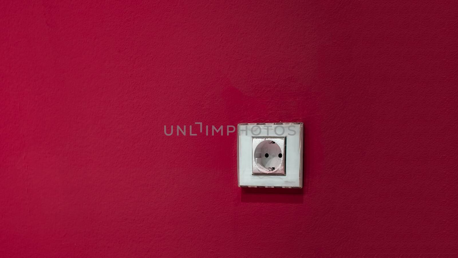 a white socket on the red wall