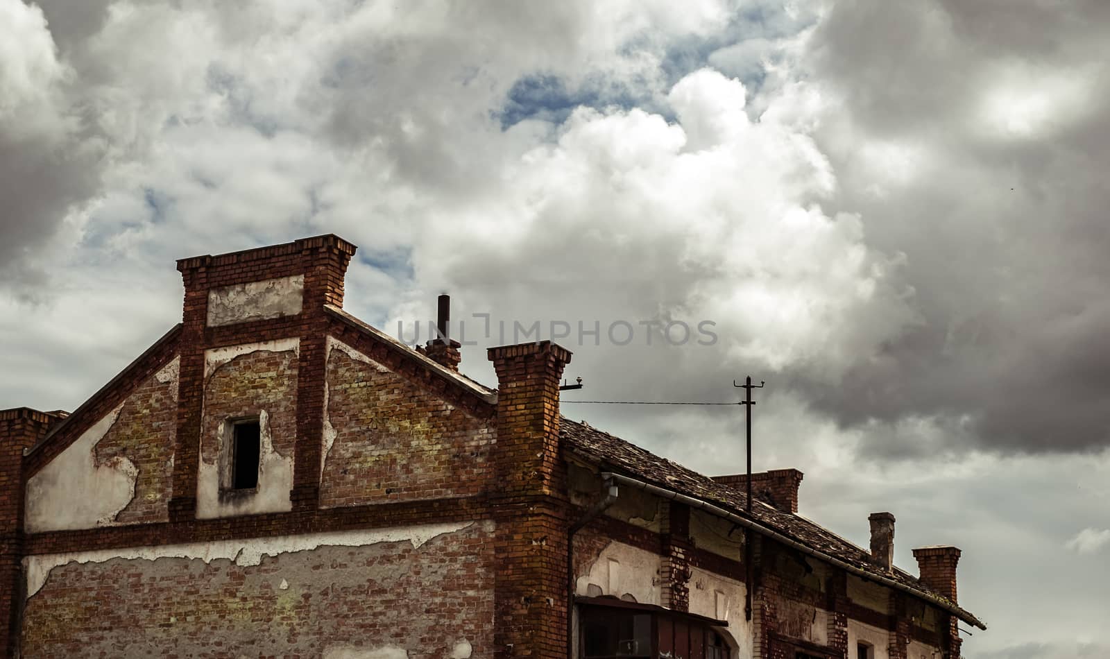 abandoned factory warehouse with broken windows and plaster fallen