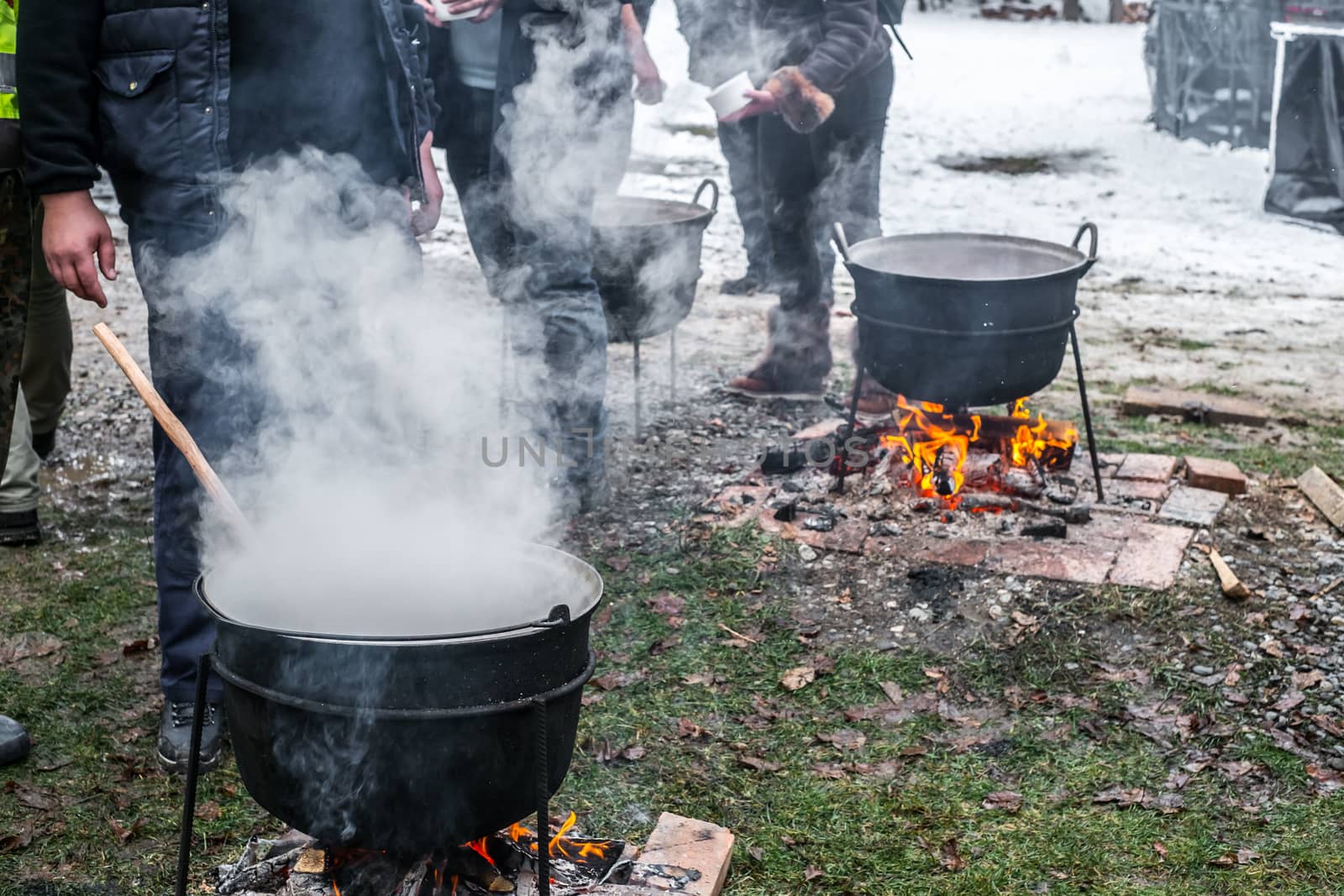 an unknown person prepares a traditional Romanian food prepared at the cauldron on the open fire, Christmas tradition
