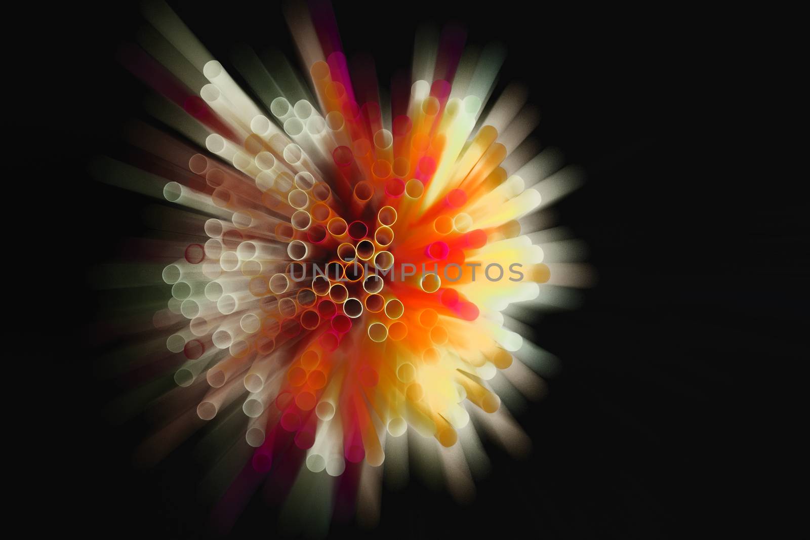 colored plastic drinking straws on black background