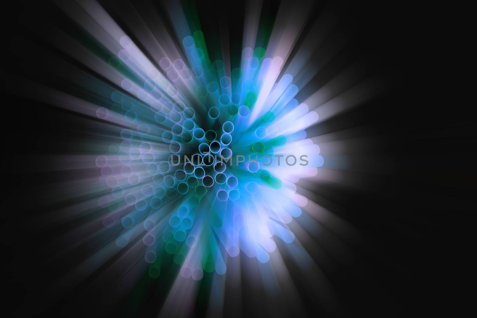 colored plastic drinking straws on black background