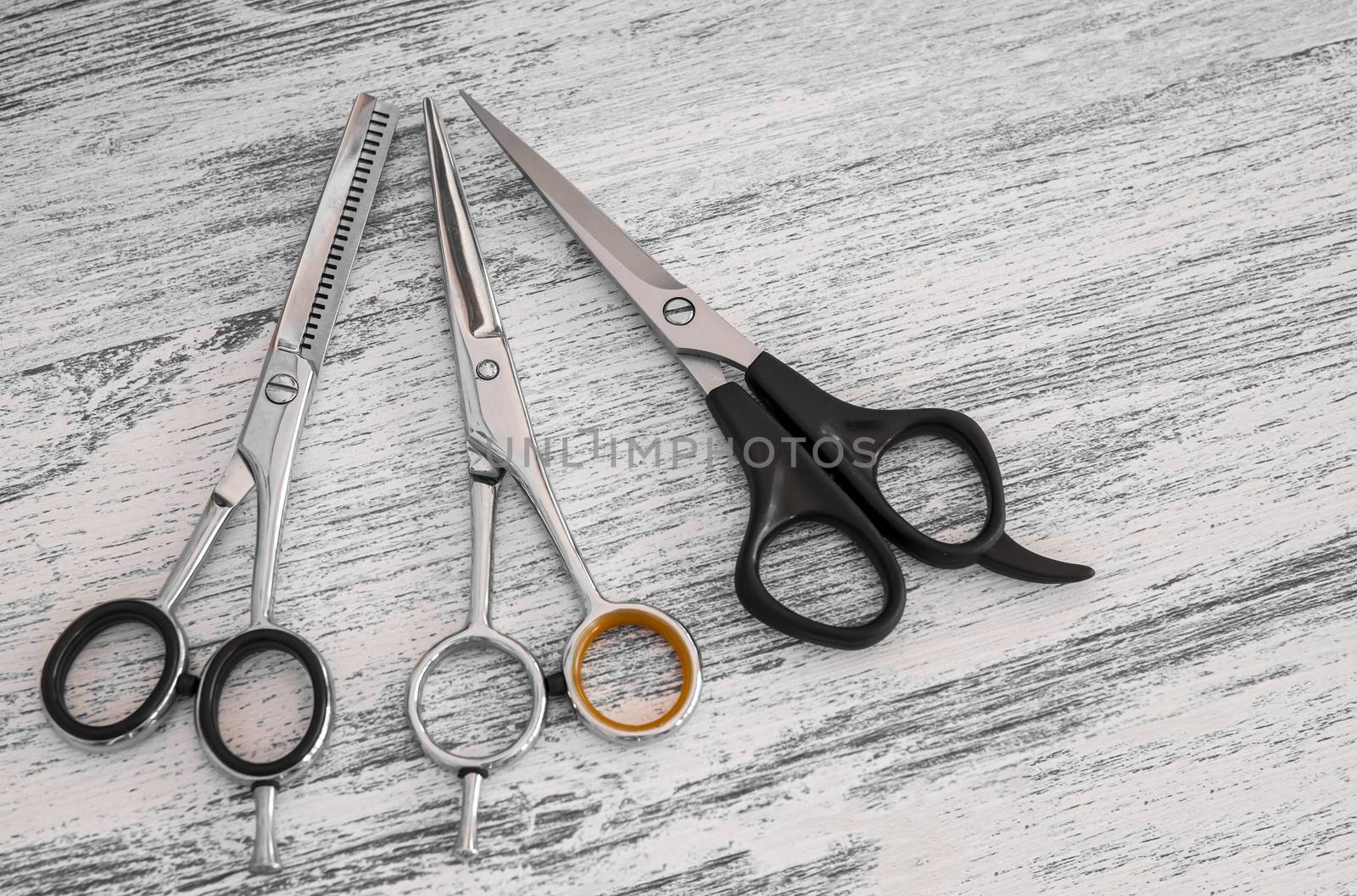 hair cutting scissors for hairdressers in beauty salon on wooden background