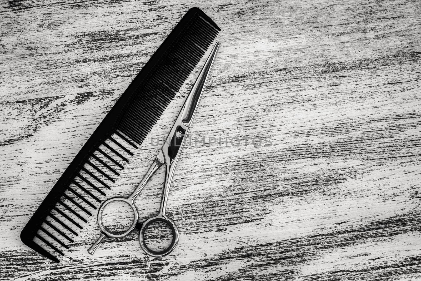 hair cutting scissor for hairdressers and comb in beauty salon on wooden background