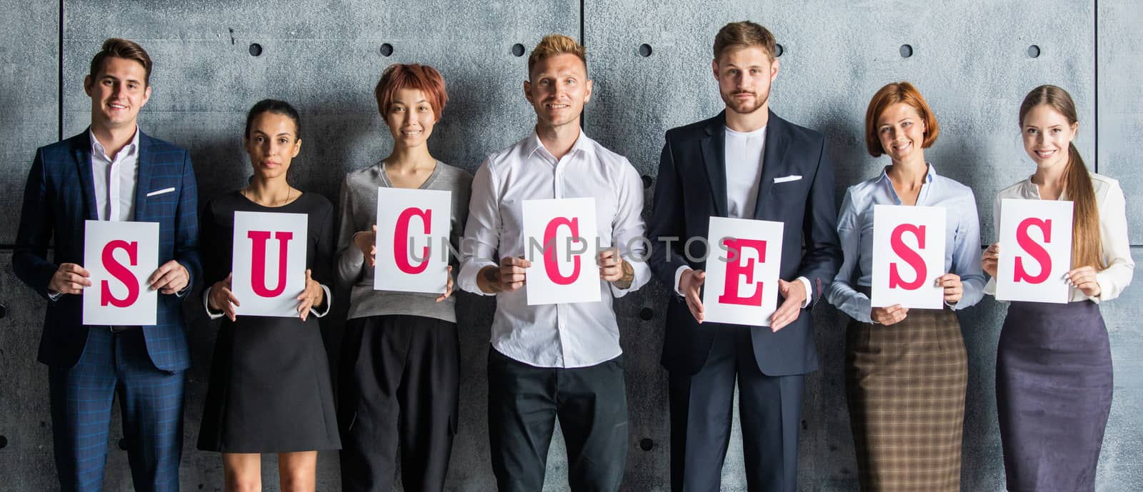 Business people holding SUCCESS letters printed on paper