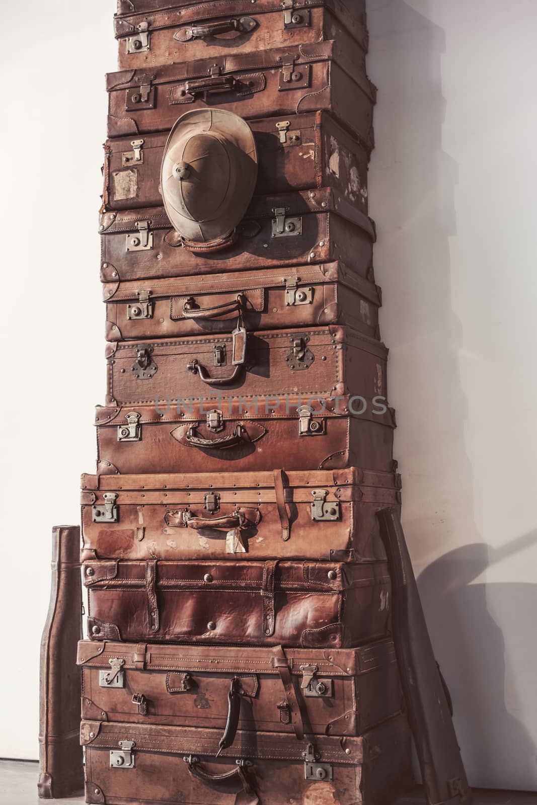 old classic leather travel suitcases with old hunting hat and two hunting guns in the sheath