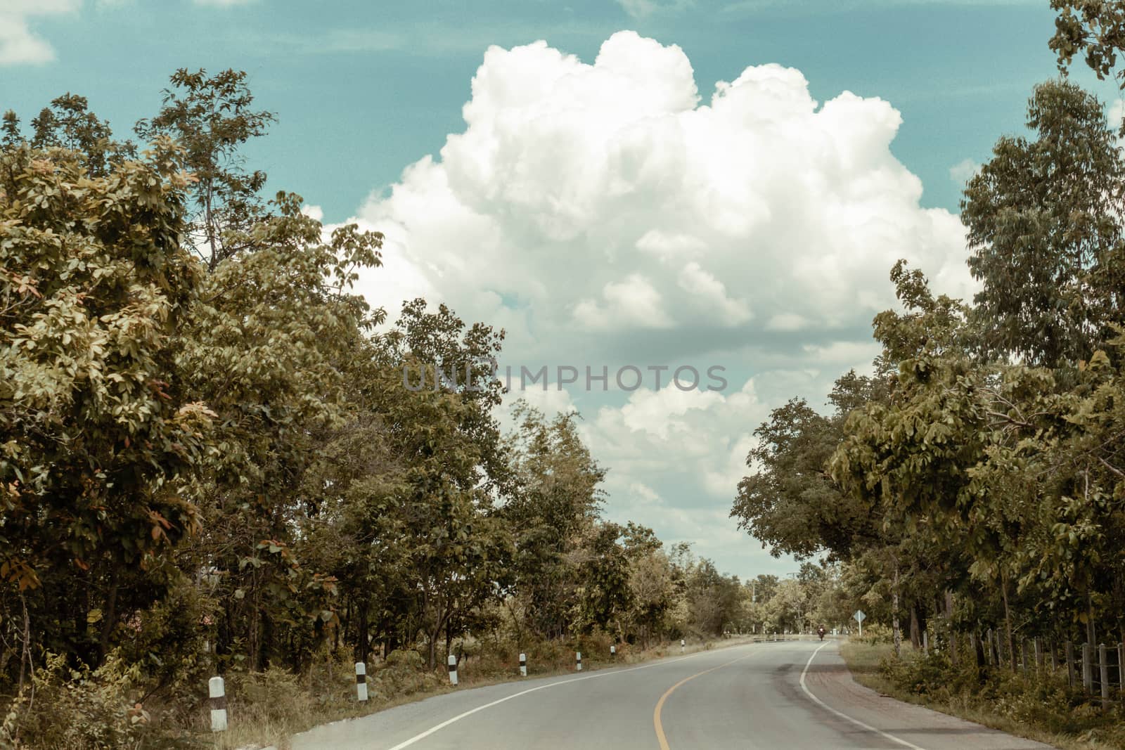 Country road with clouds and blue sky 
