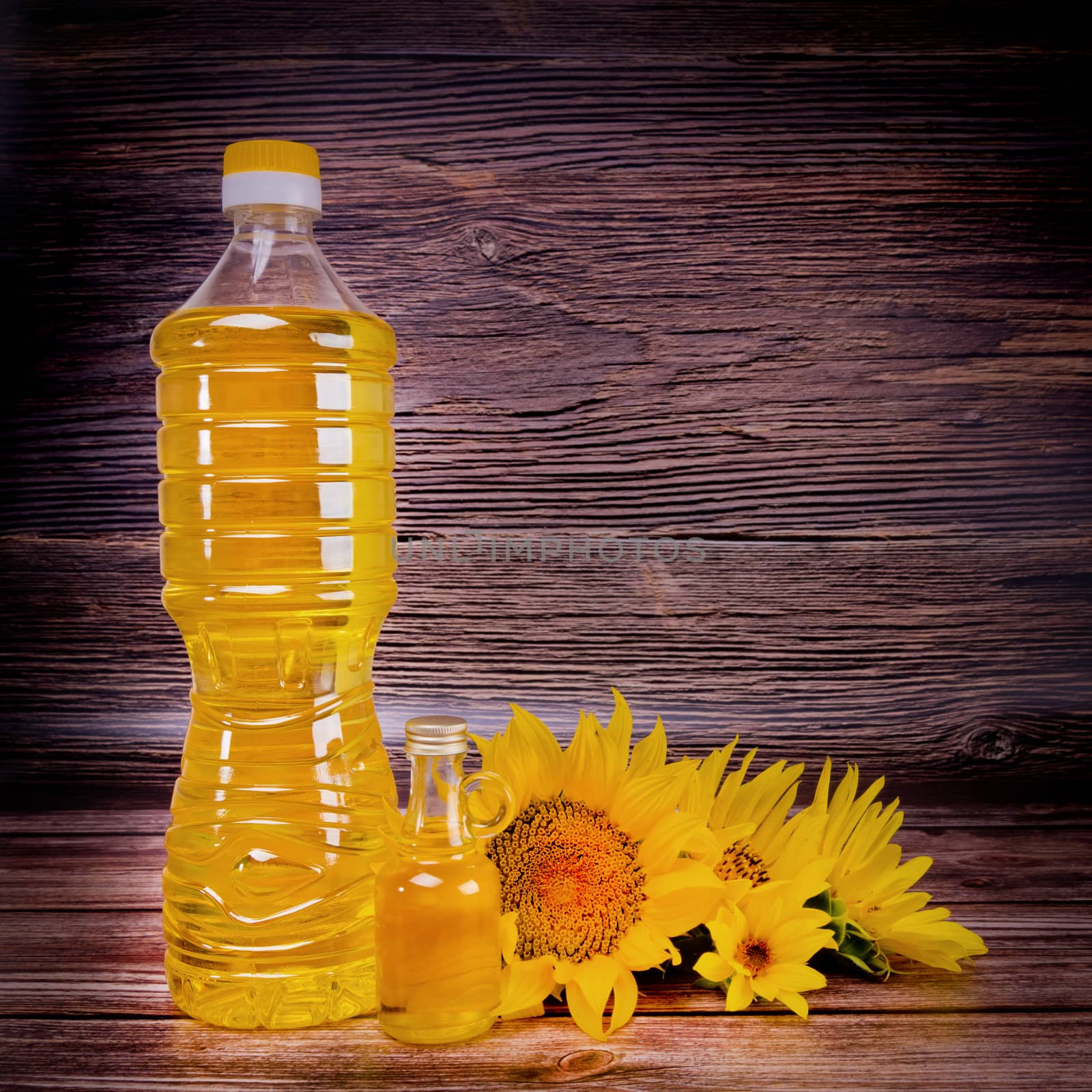 Sunflower oil with flowers on rustic wooden background. Studio shot. by leonik