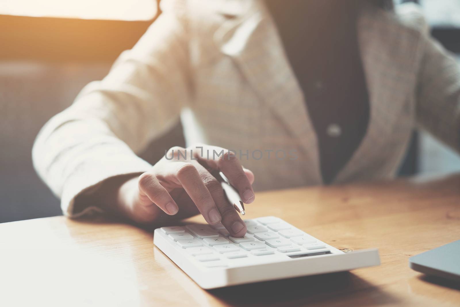 Close up Businesswoman using calculator and laptop for do math f by wichayada