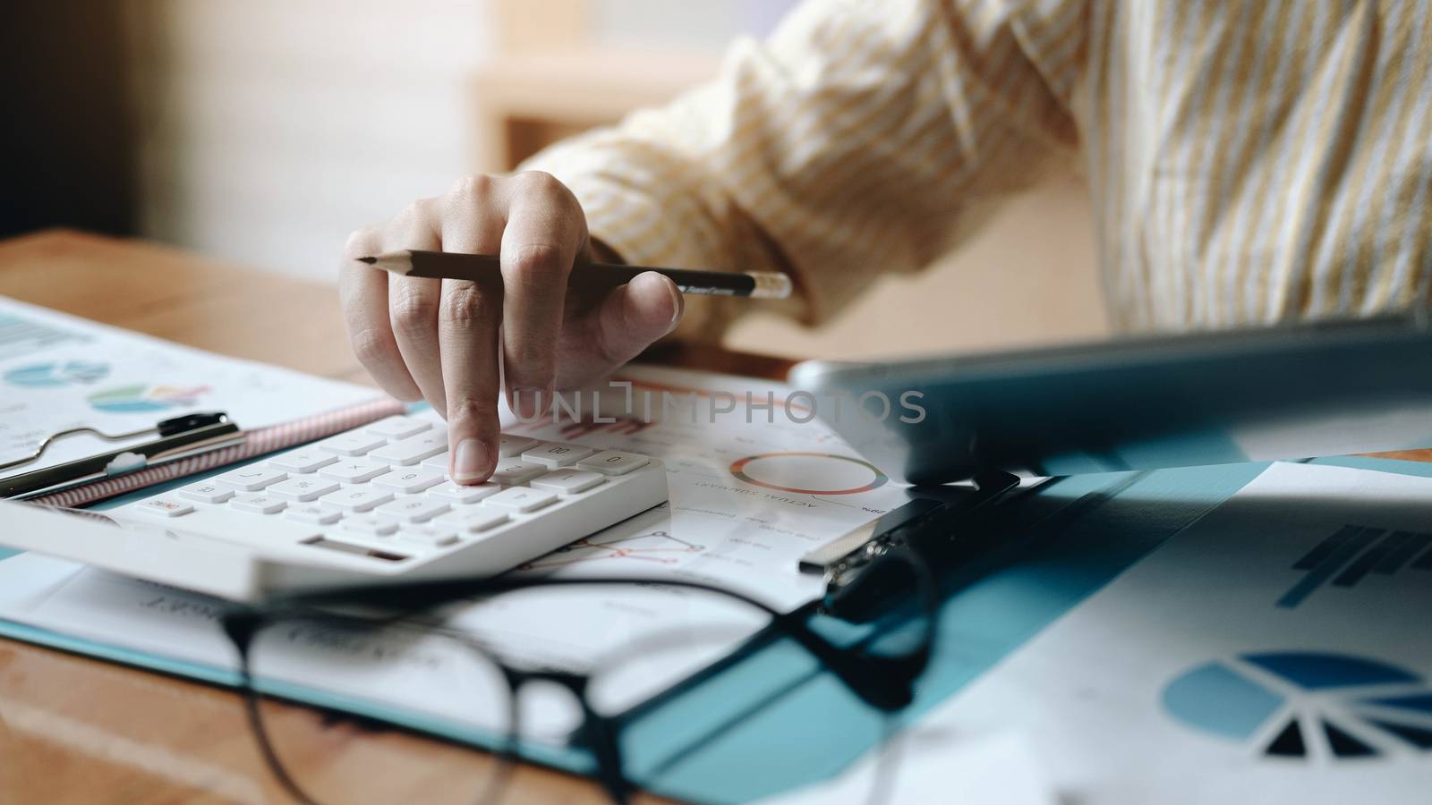 woman accounting using calculating and work with laptop computer by wichayada