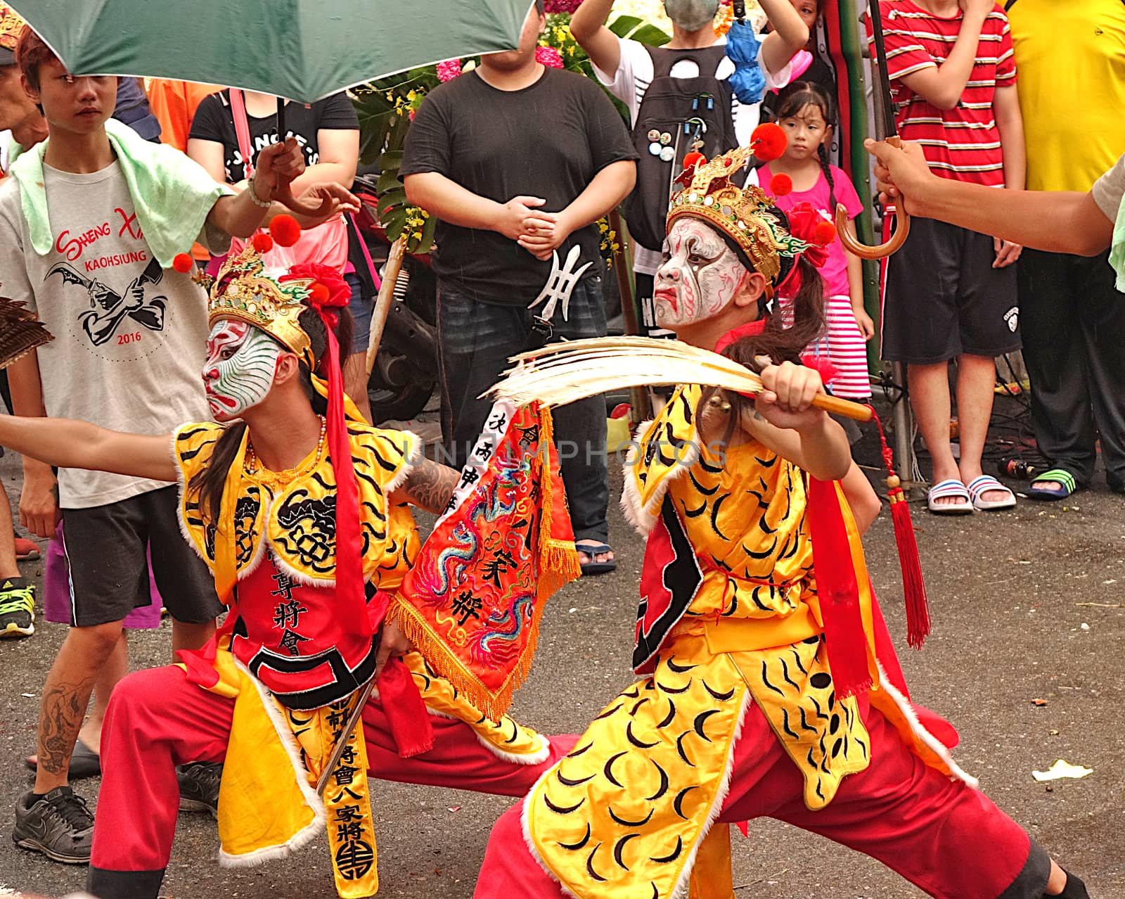 KAOHSIUNG, TAIWAN -- JULY 9, 2016: Male dancers with face painted masks perform during a traditional religious temple ceremony.