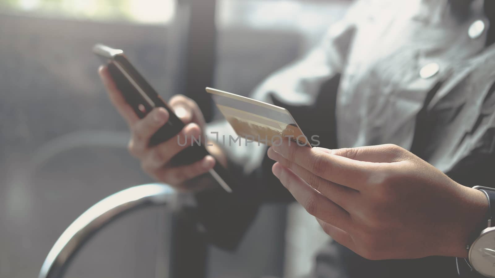 Online payment,woman's hands holding a credit card and using smartphone for online shopping.